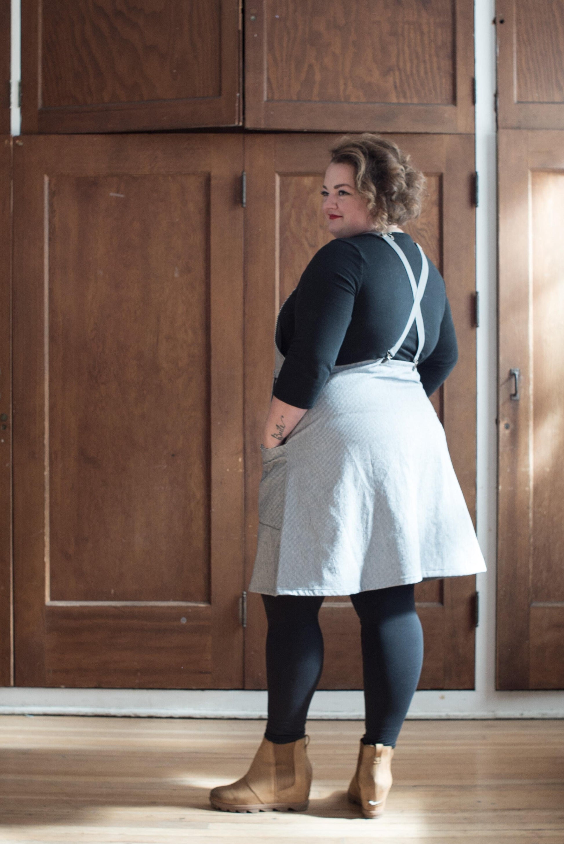 Model at 3/4 view Railroad Stripe Suspender Dress.