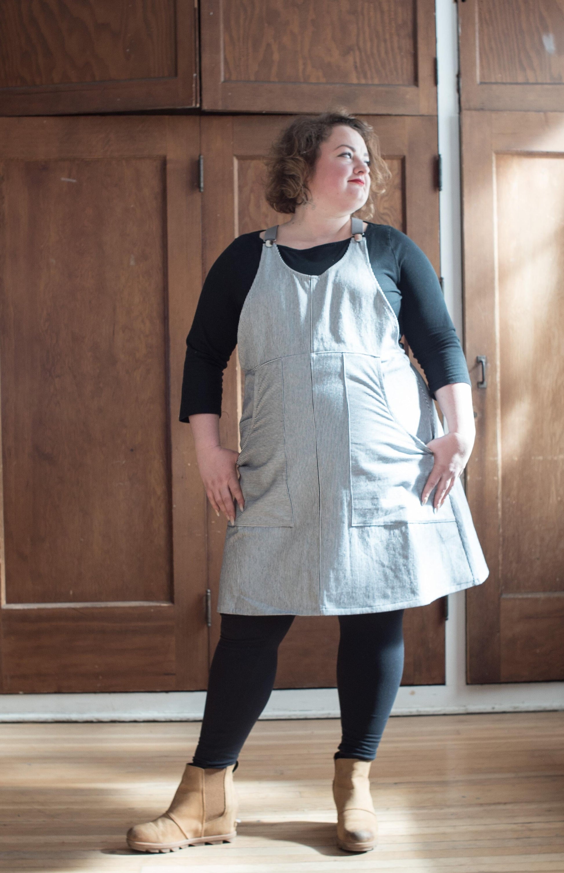 Model facing forward wearing Railroad Stripe Suspender Dress.