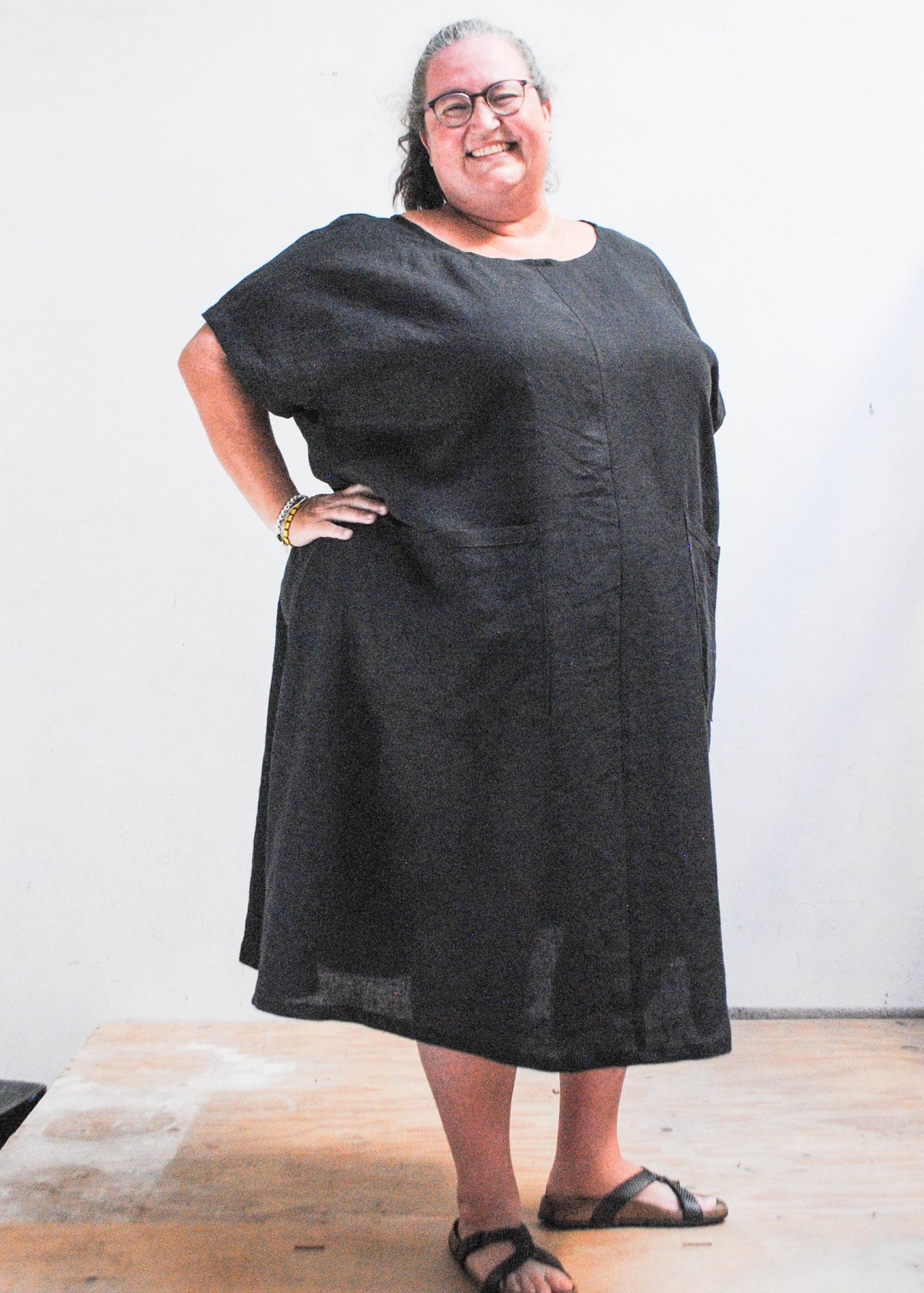 Emily models the Black Linen Basic Dress with hand on her hip. Size 5XL.