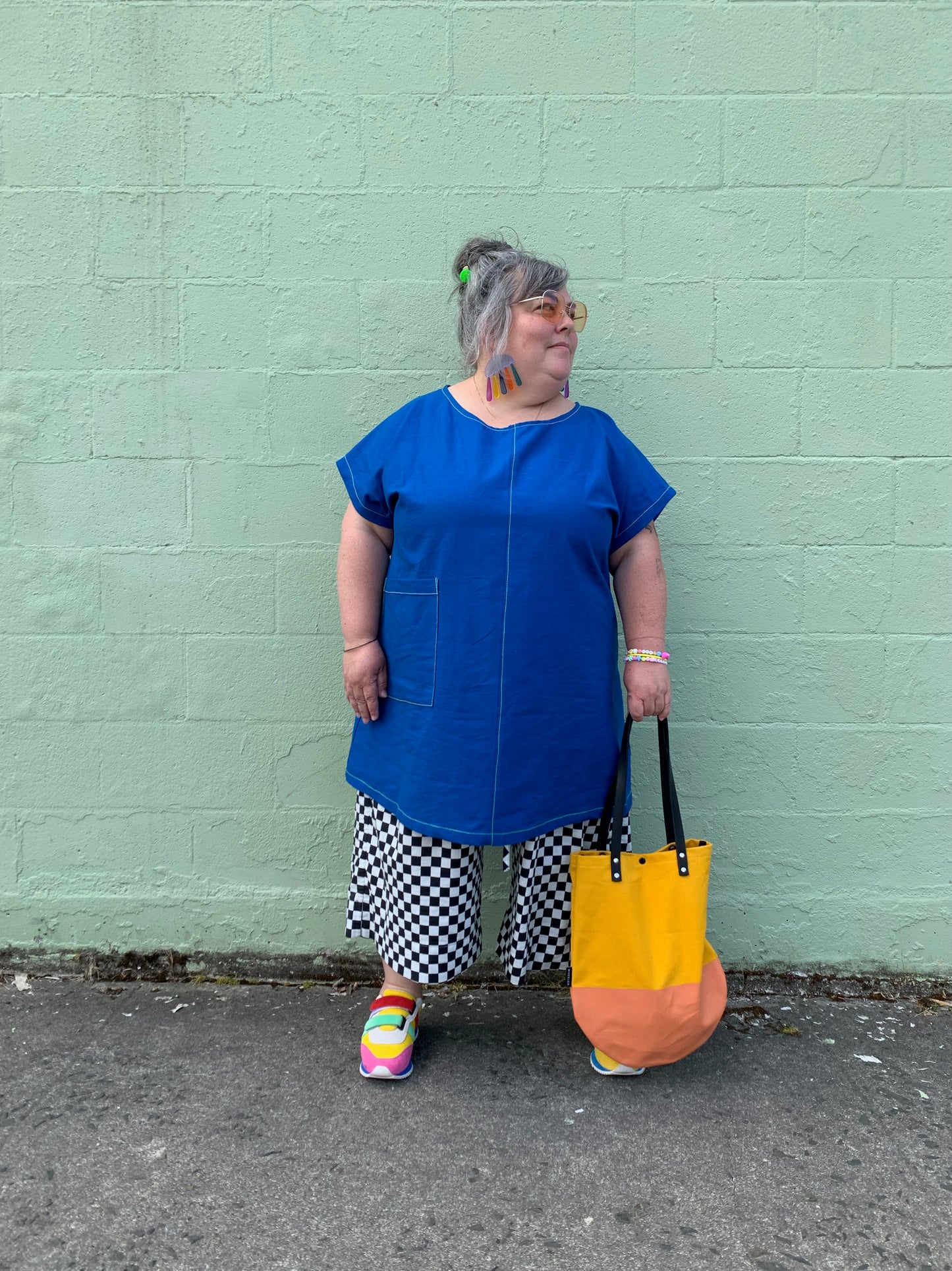 Brightest blue tunic with neon yellow/green topstitching and one big pocket. 55% linen, 45% cotton, medium weight.Model is holding yellow round bottom bag.