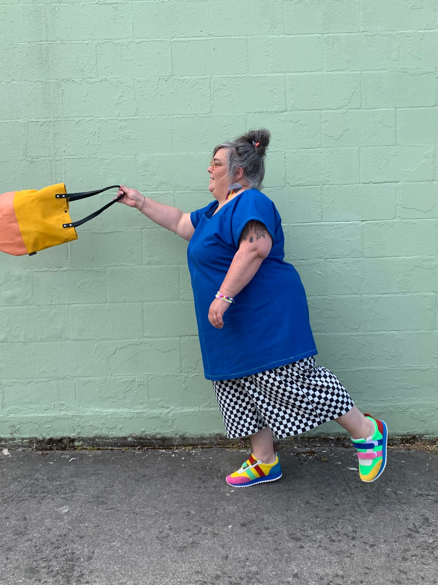 Brightest blue tunic with neon yellow/green topstitching and one big pocket. 55% linen, 45% cotton, medium weight. Model is holding yellow round bottom bag.