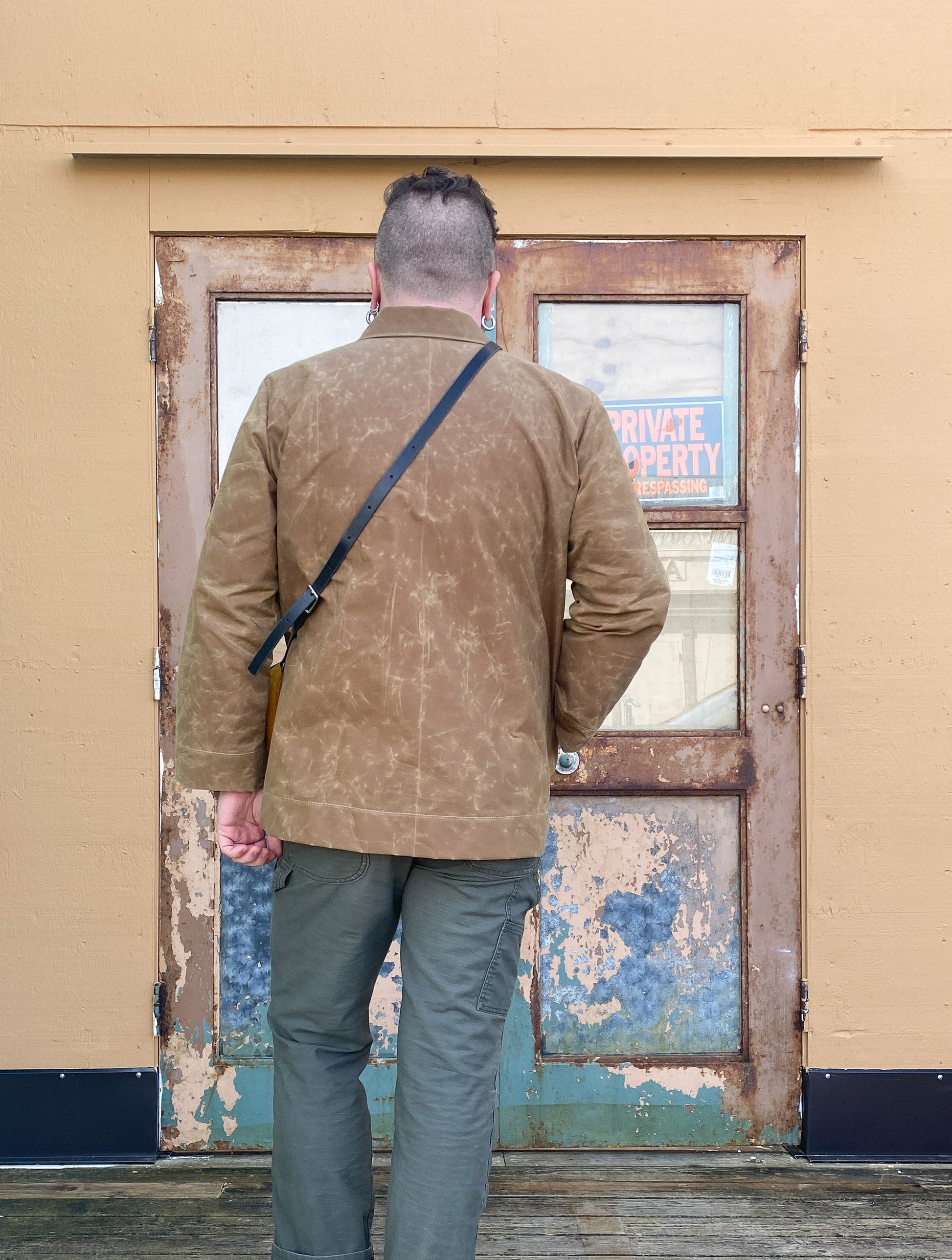 Model's back in Waxed Canvas Work Jacket in tan.