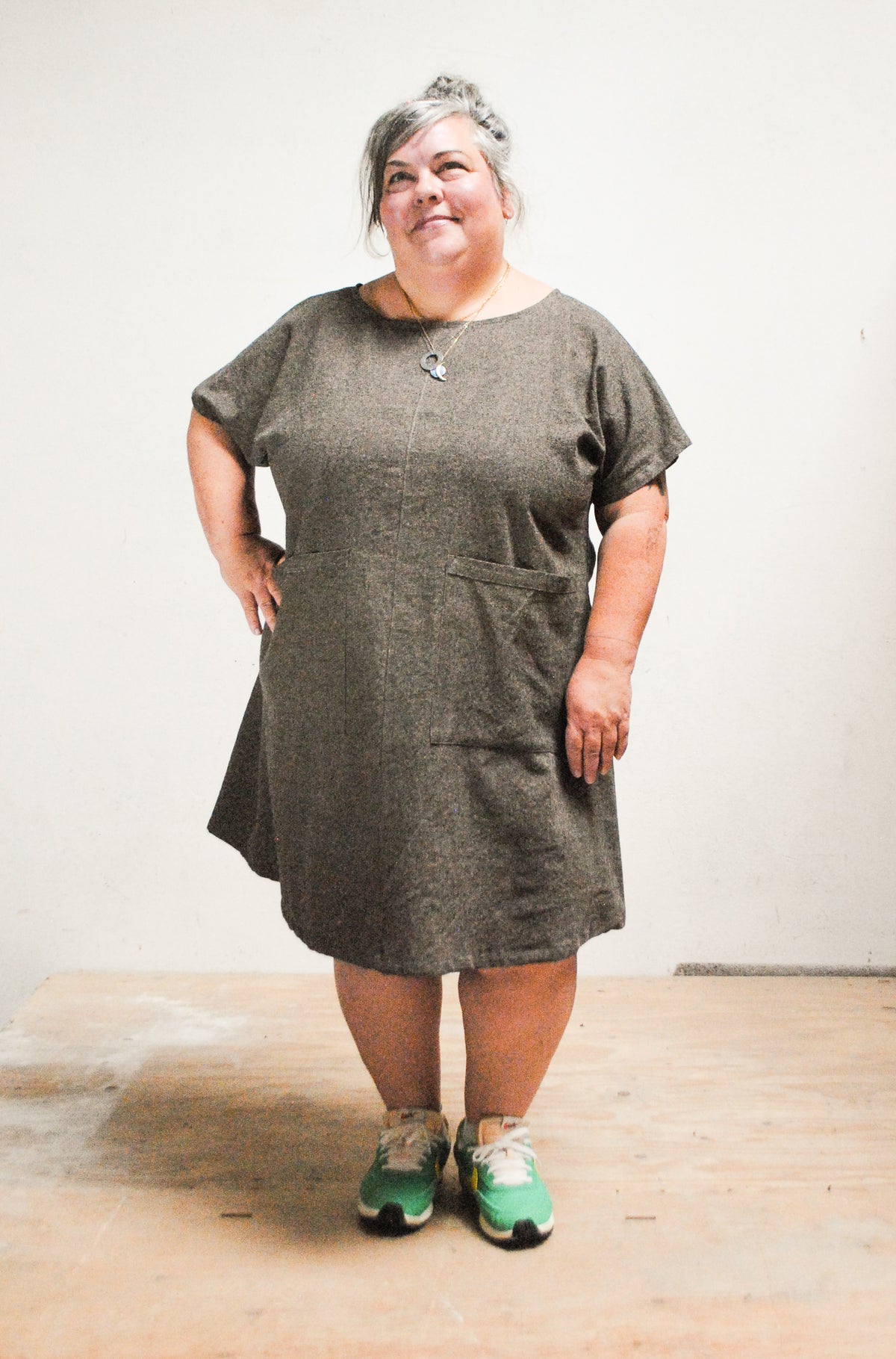 Model wearing handmade Shift + Wheeler mini dress in Espresso, one hand on hip