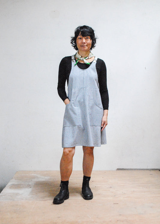 Front view of model wearing railroad stripe suspender dress