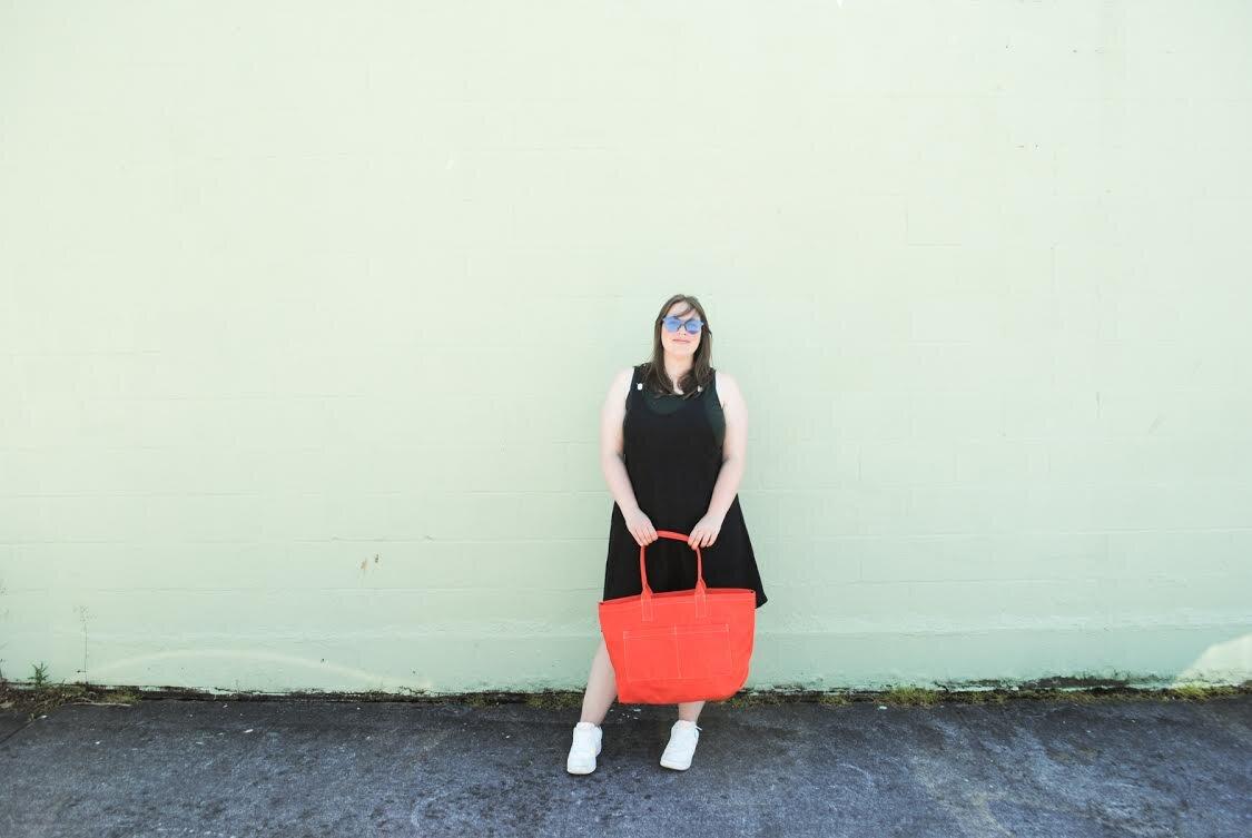 Model wearing black linen suspender dress, holding a Wheeler Bag Co. orange beach tote. this 100% linen, 7oz (medium weight) is super SUPER soft, flowy, and has a very nice hand. Slightly nubby weave gives it character and texture.