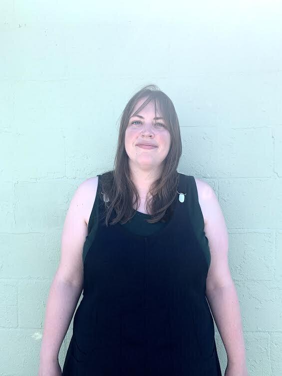 Cropped view of model wearing black linen suspender dress. this 100% linen, 7oz (medium weight) is super SUPER soft, flowy, and has a very nice hand. Slightly nubby weave gives it character and texture.