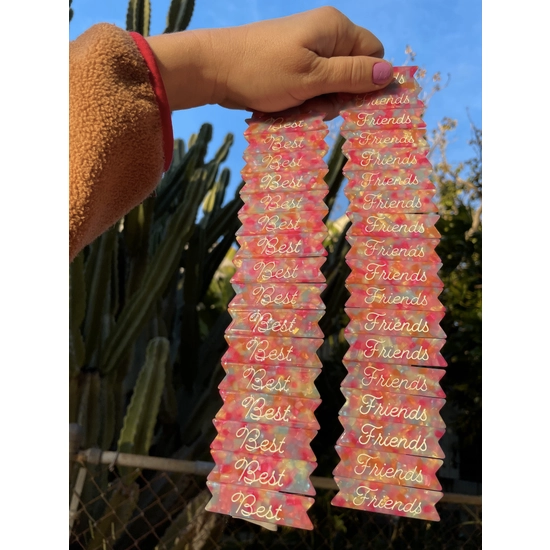 Model holding two stacks of "Best Friends" confetti acetate hair clip set.
