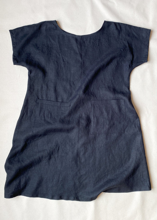 A-line, longer linen dress has two big patch pockets on the front.