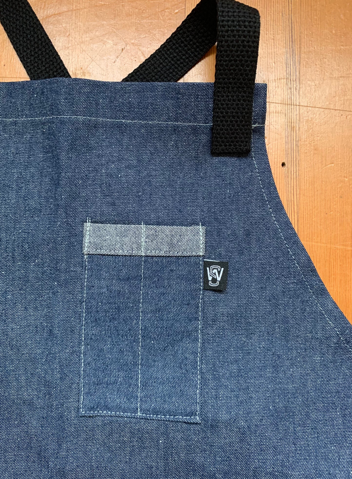 Pocket detail of denim cross back apron.