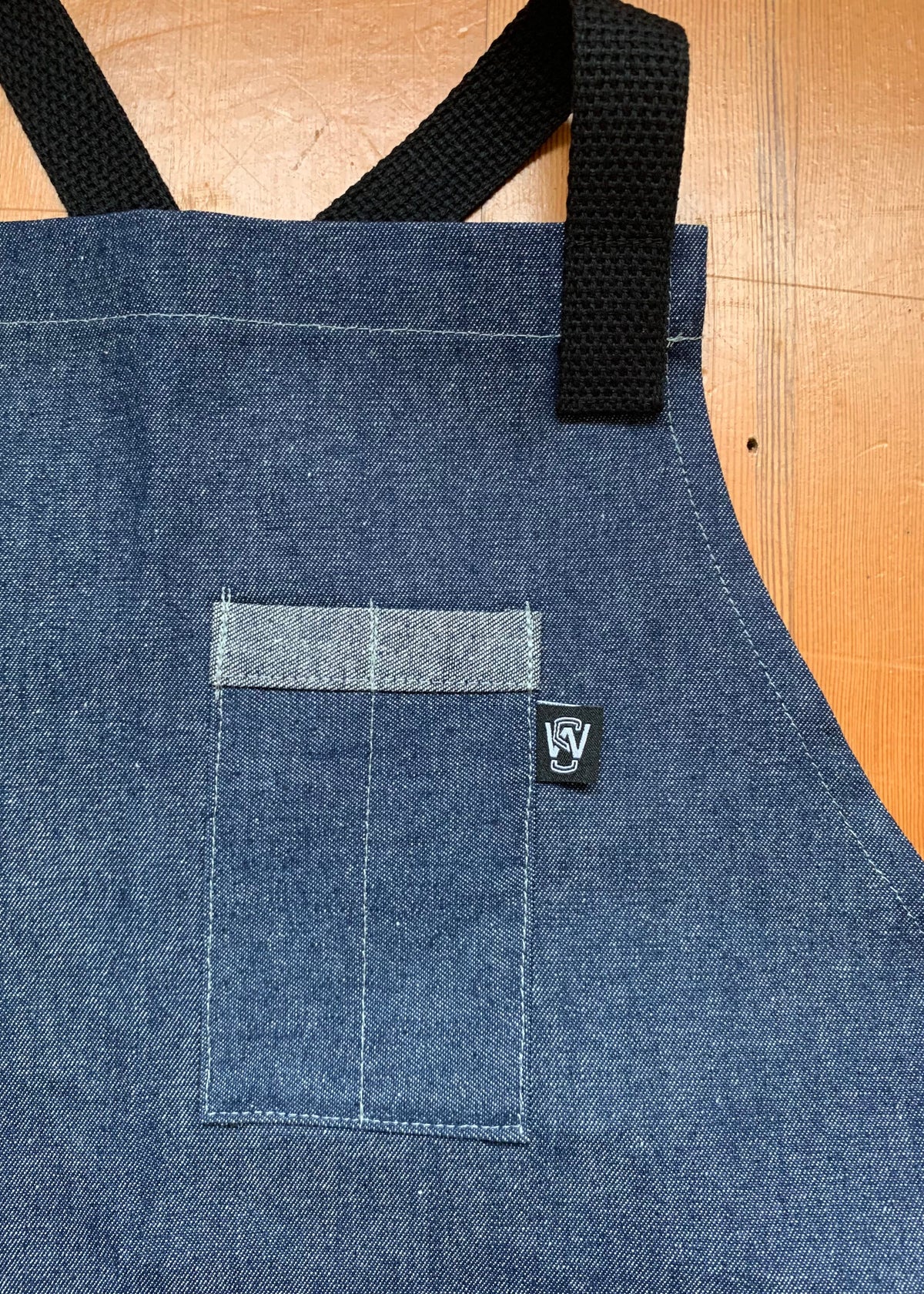 Pocket detail of denim cross back apron.