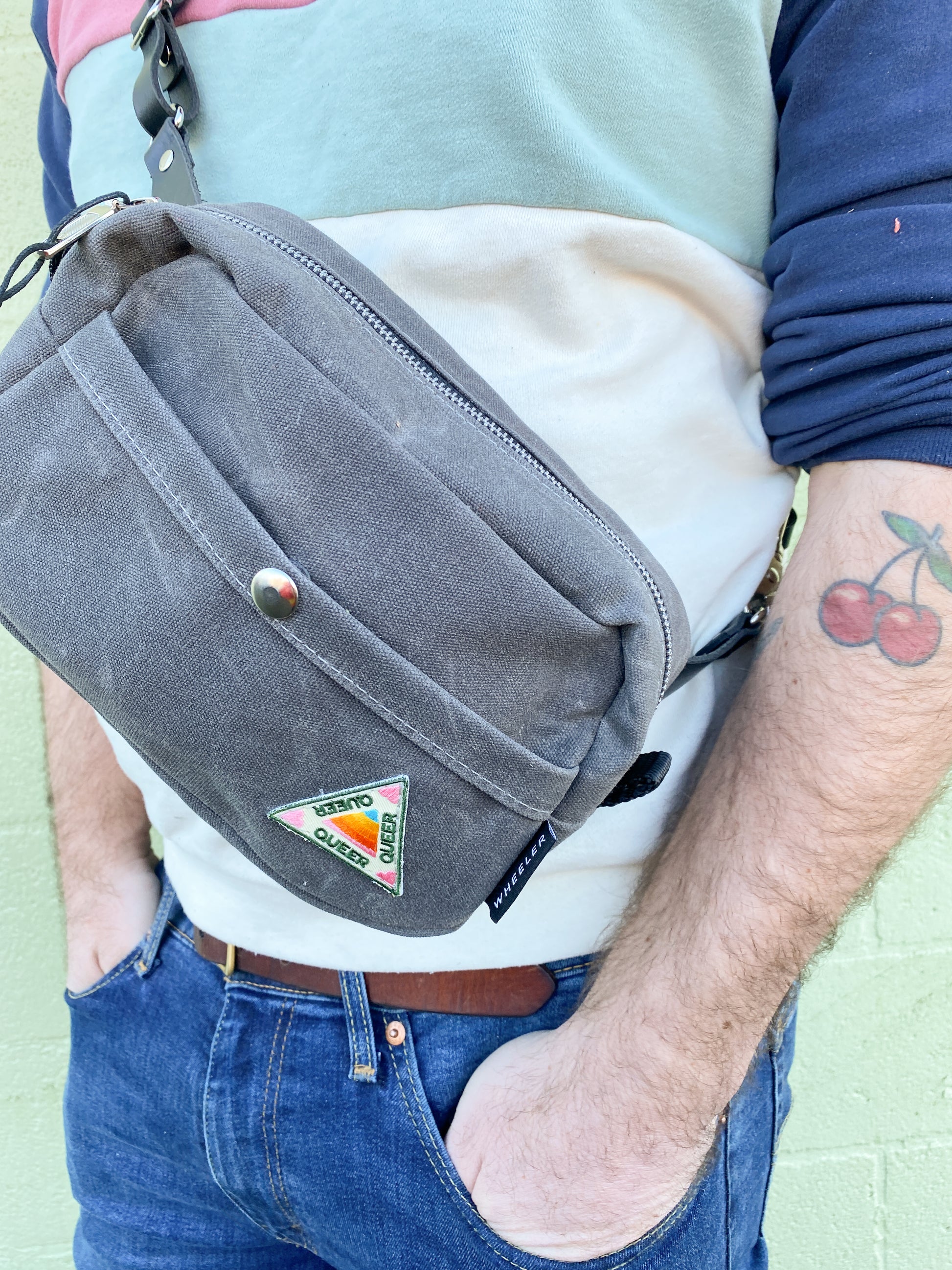 Waxed Charcoal canvas with black leather strap, snap front detail.