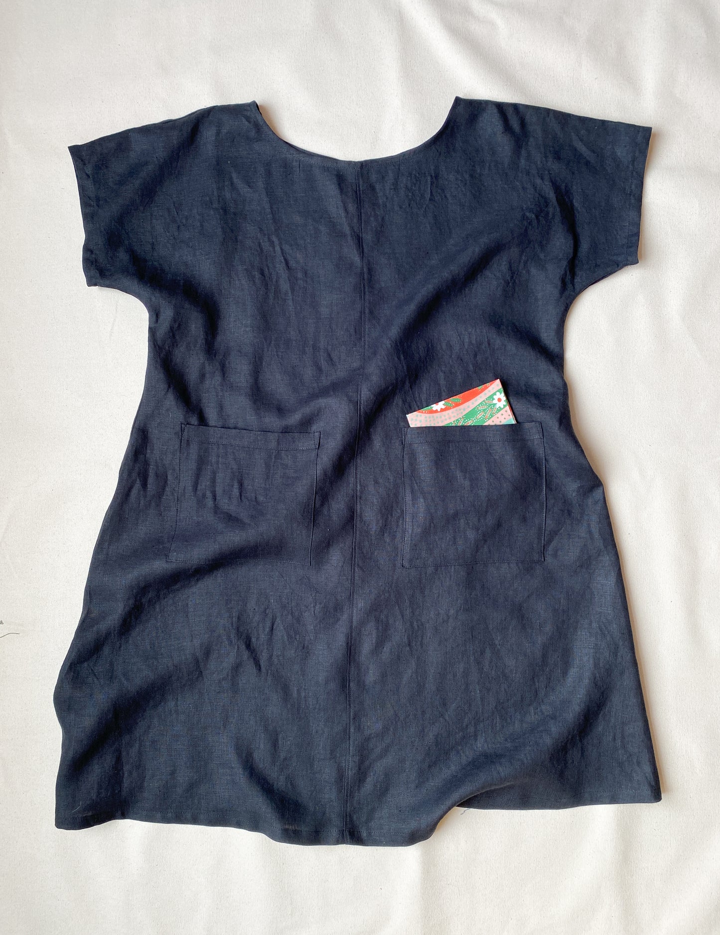 A-line, longer linen dress has two big patch pockets on the front