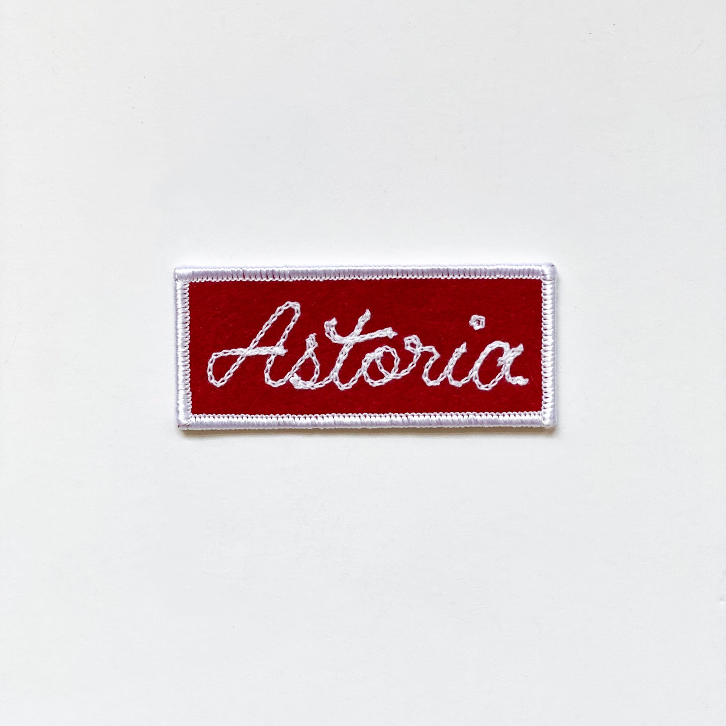 Handmade, custom "Astoria" rectangle patch in red felt with white embroidery.