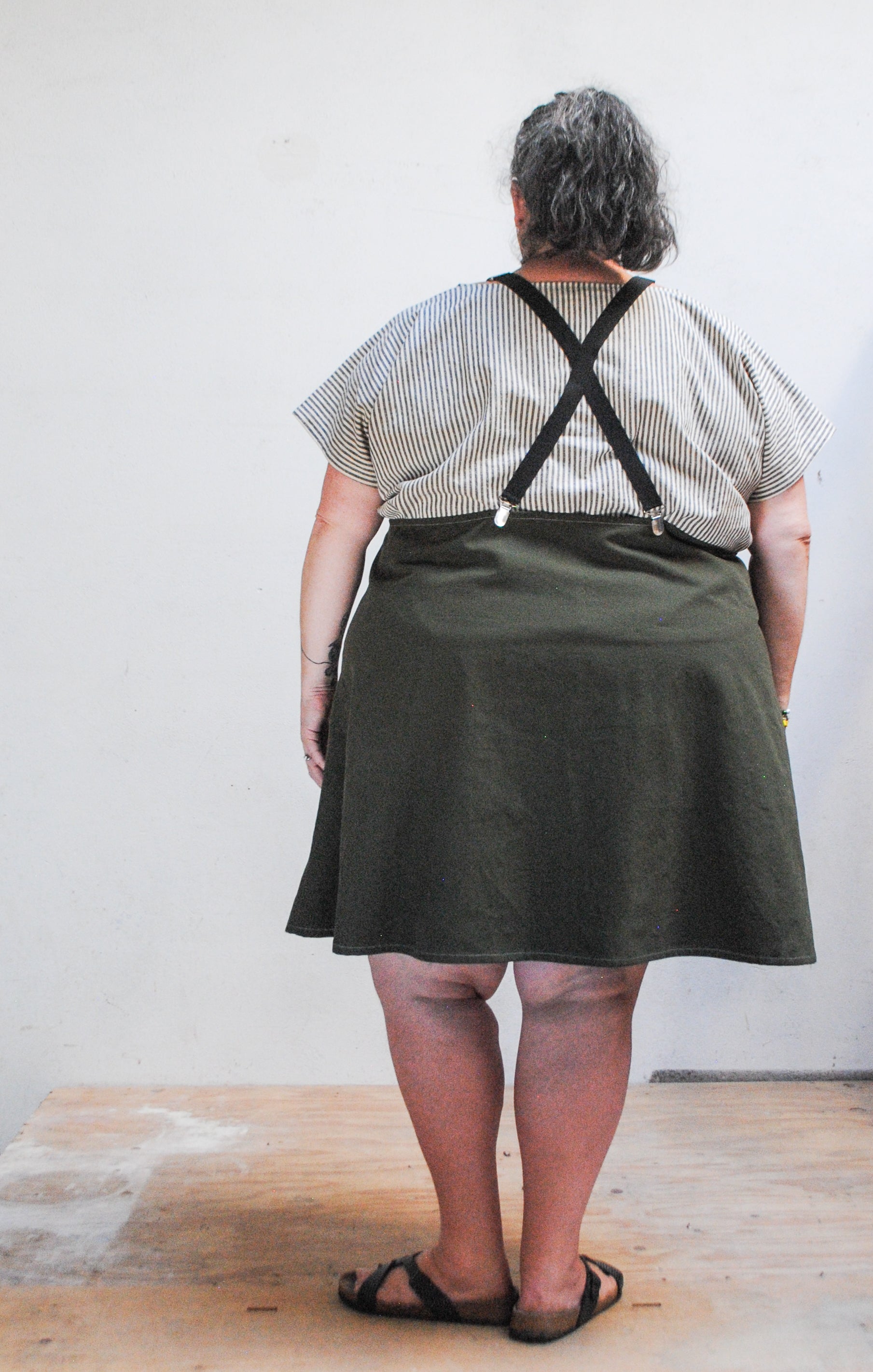 Back view of evergreen brushed canvas suspender dress, pinafore style