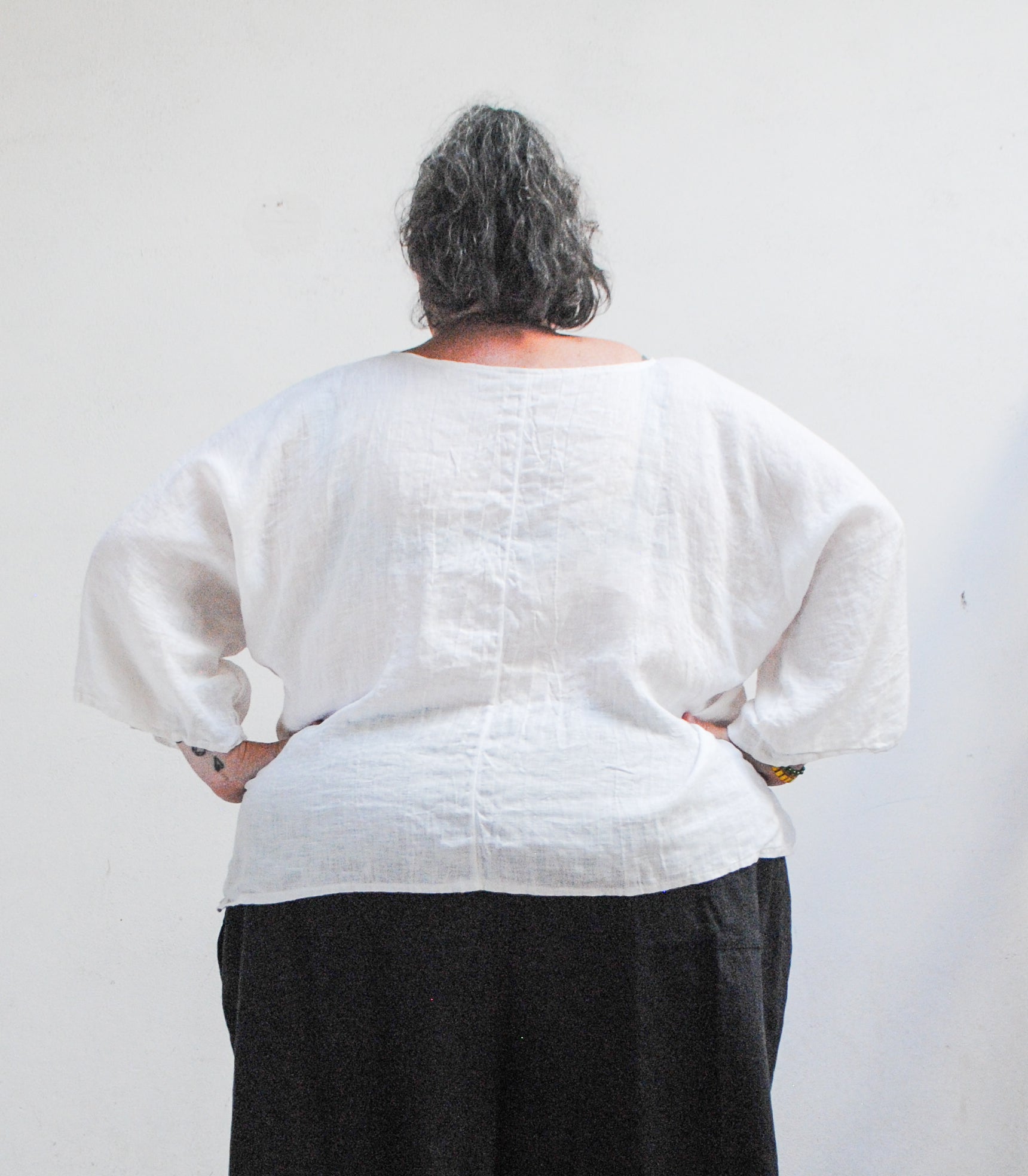Back view of sheer white linen ghost shirt showing center back seam
