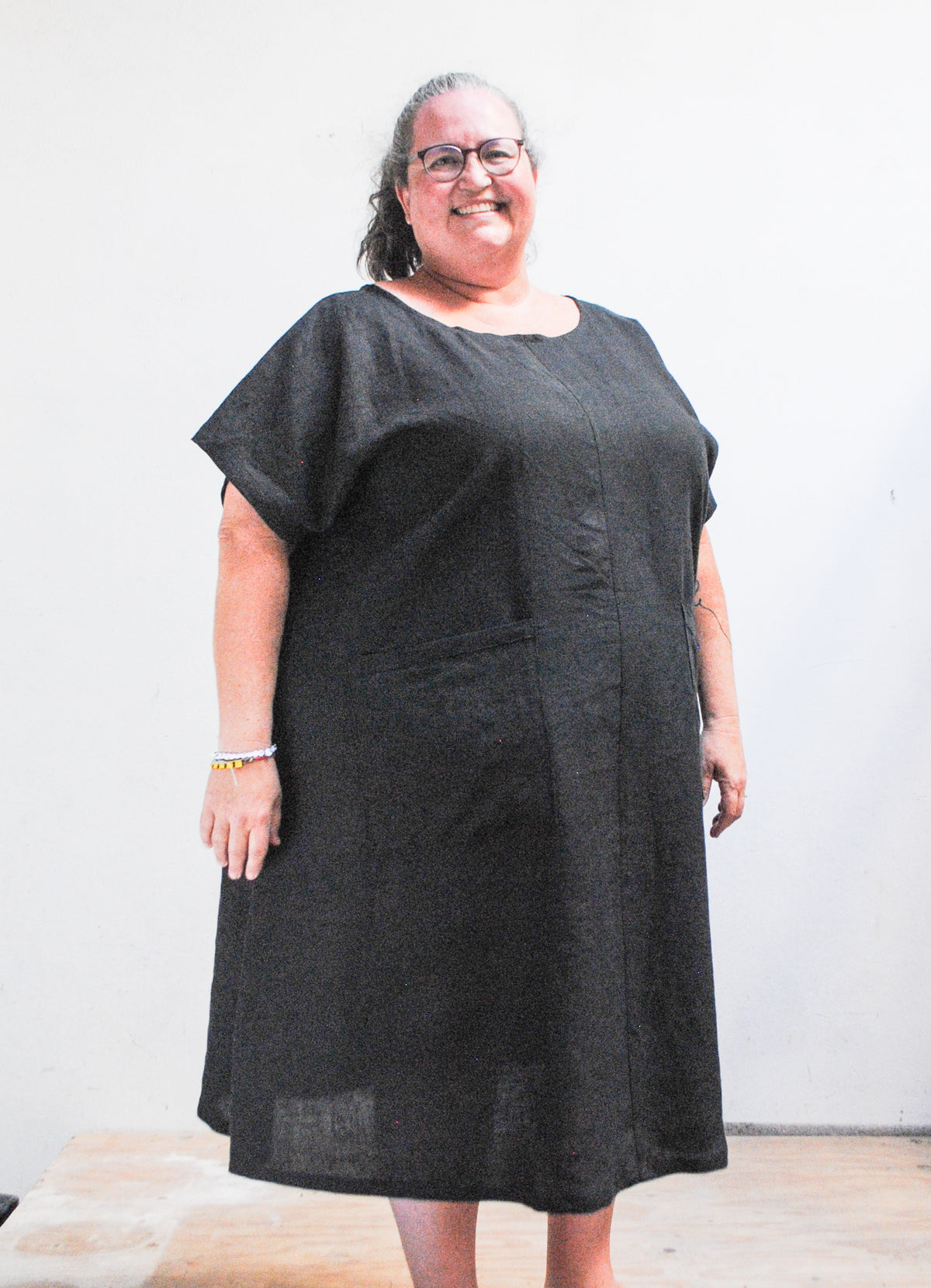 Handmade black linen A-line dress with patch pockets, front view, made in Astoria Oregon USA