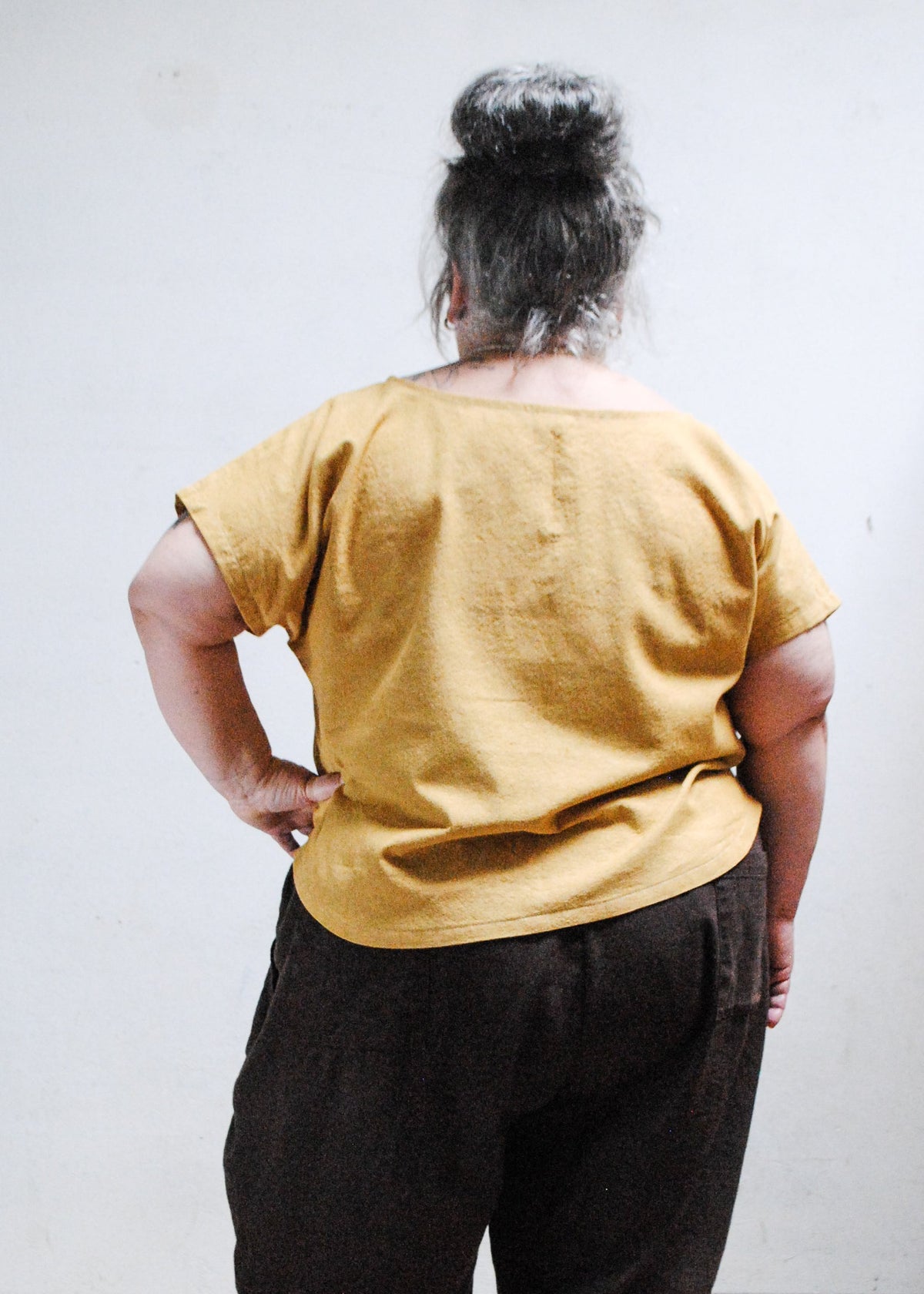 Model wearing Goldie crop tee with hand on hip - back view