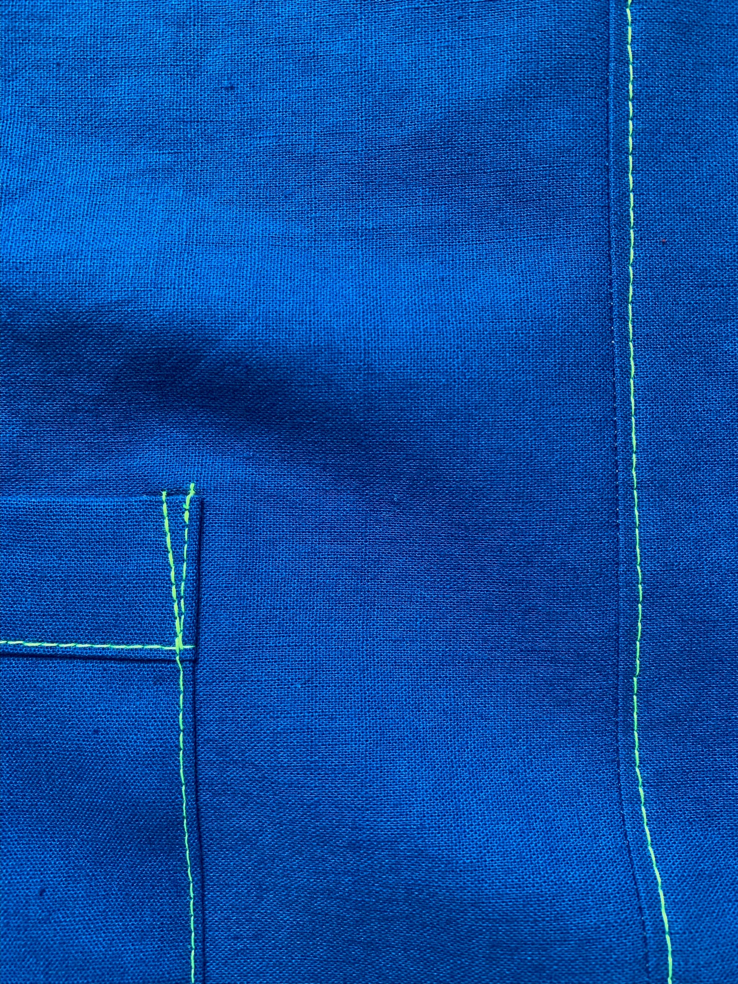 Brightest blue tunic with neon yellow/green topstitching and one big pocket. 55% linen, 45% cotton, medium weight.