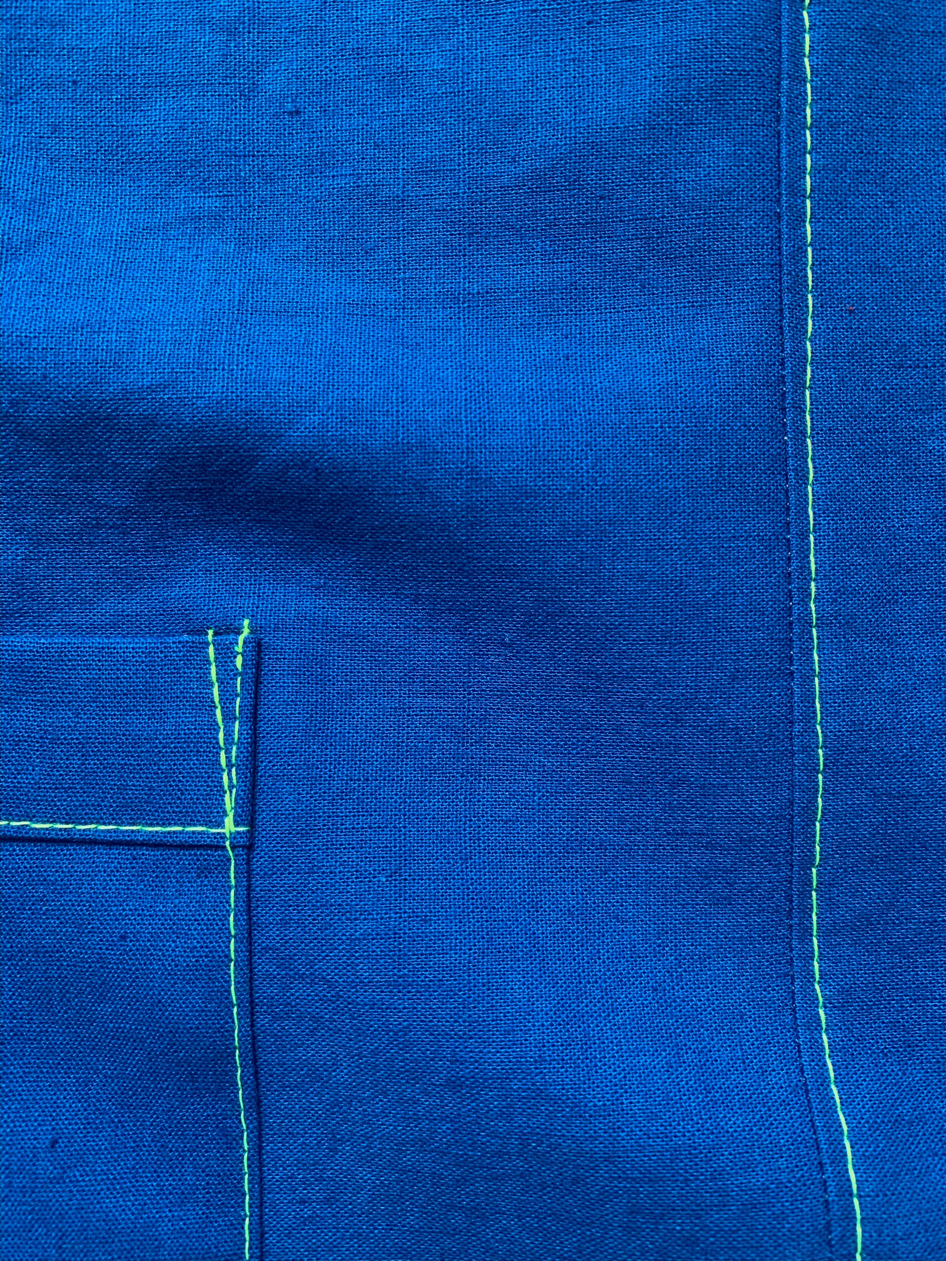 Brightest blue tunic with neon yellow/green topstitching and one big pocket. 55% linen, 45% cotton, medium weight.