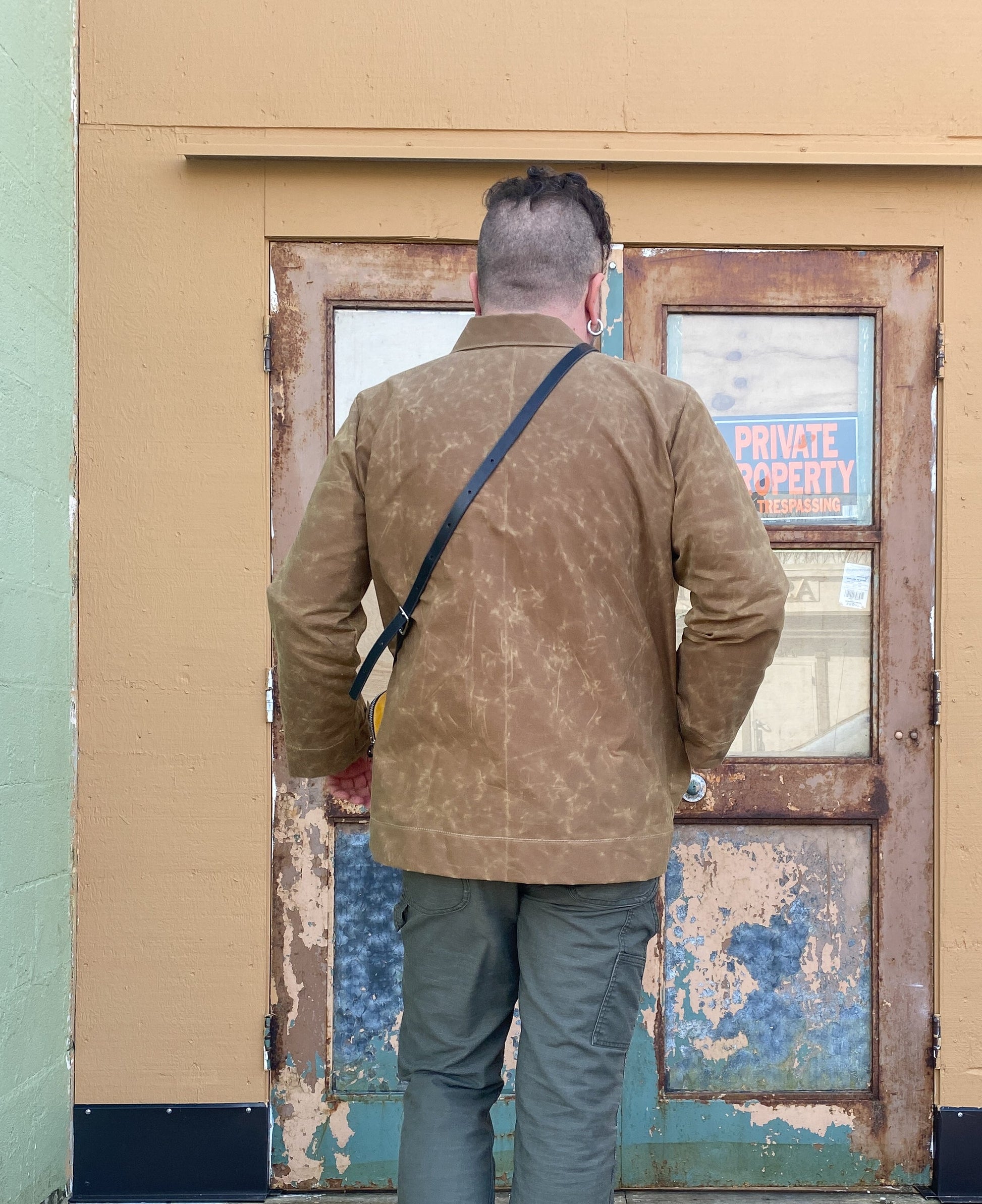 Model's back in Waxed Canvas Work Jacket in tan.