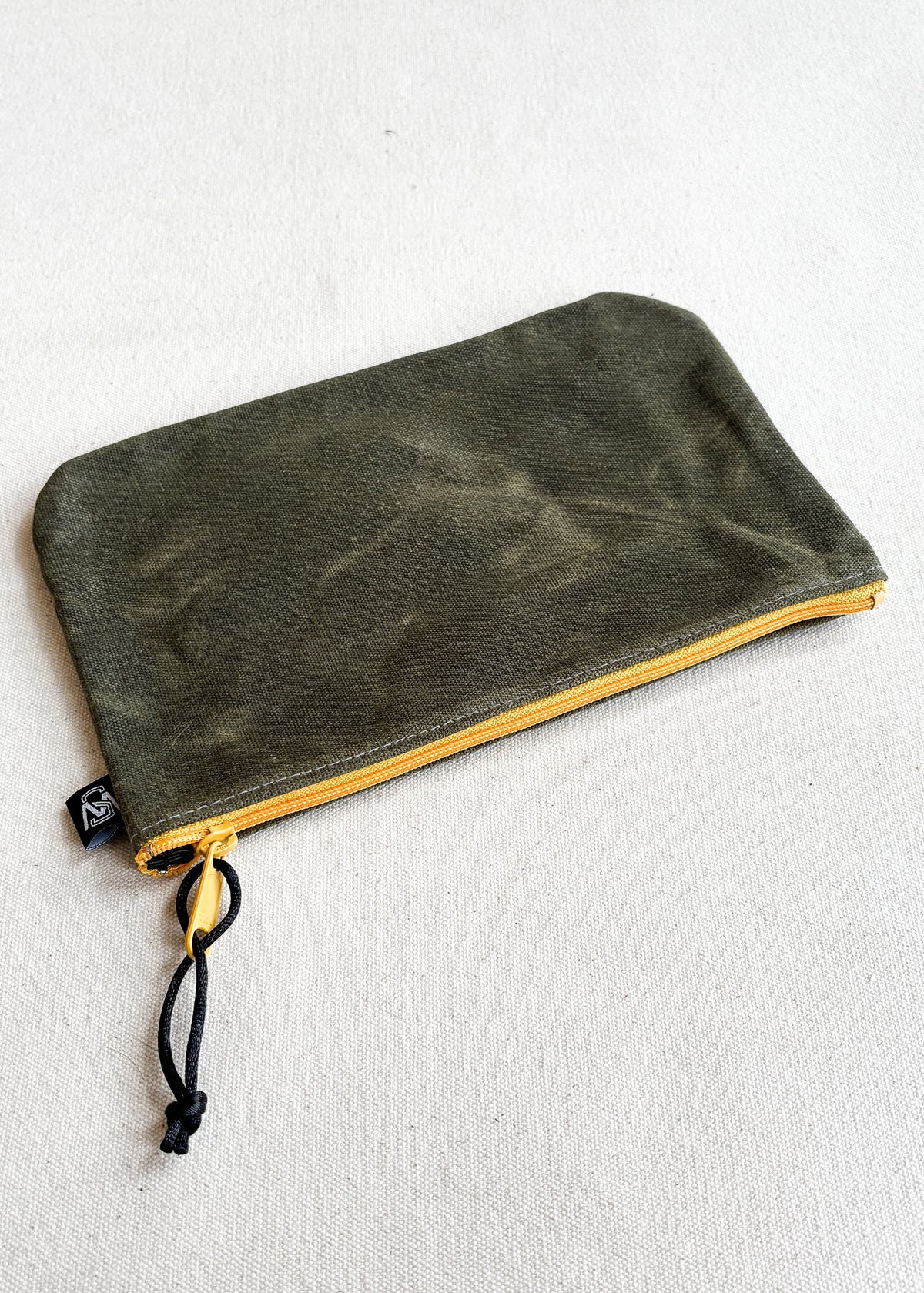 Large waxed canvas zipper pouch in olive with yellow zipper