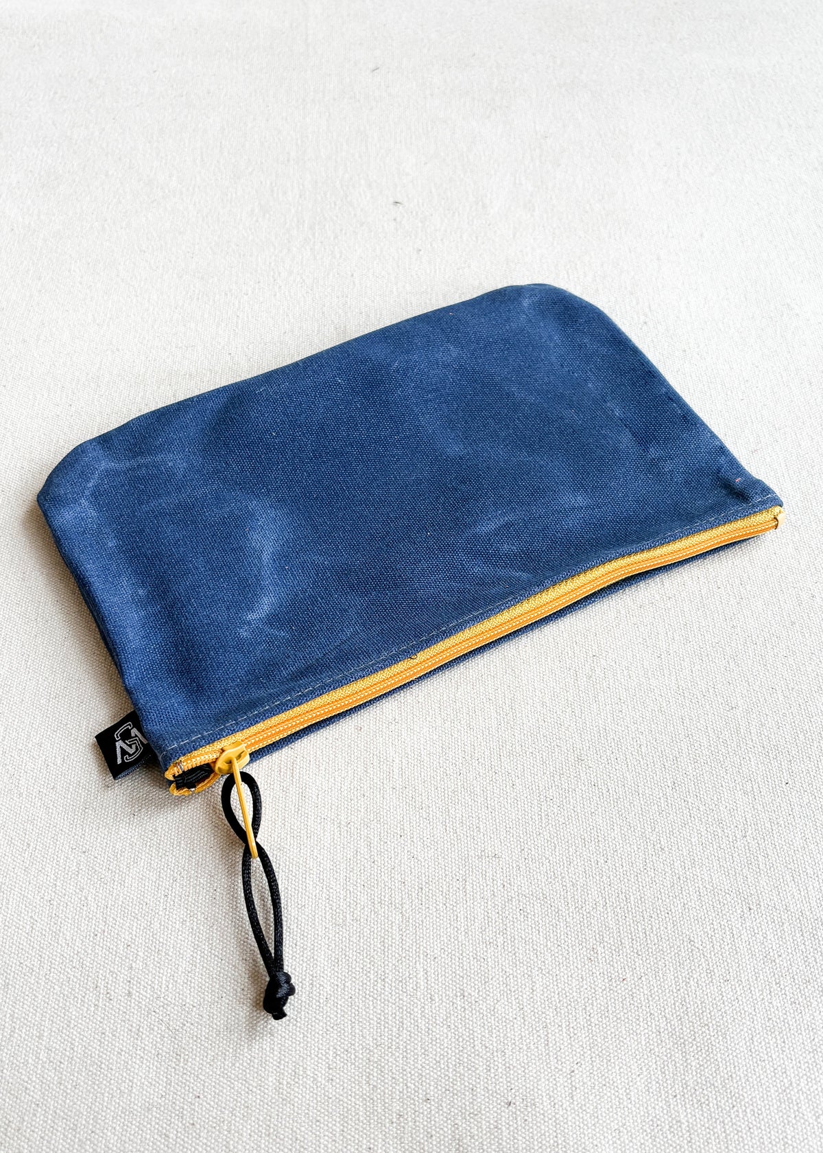 Large waxed canvas zipper pouch in royal with yellow zipper