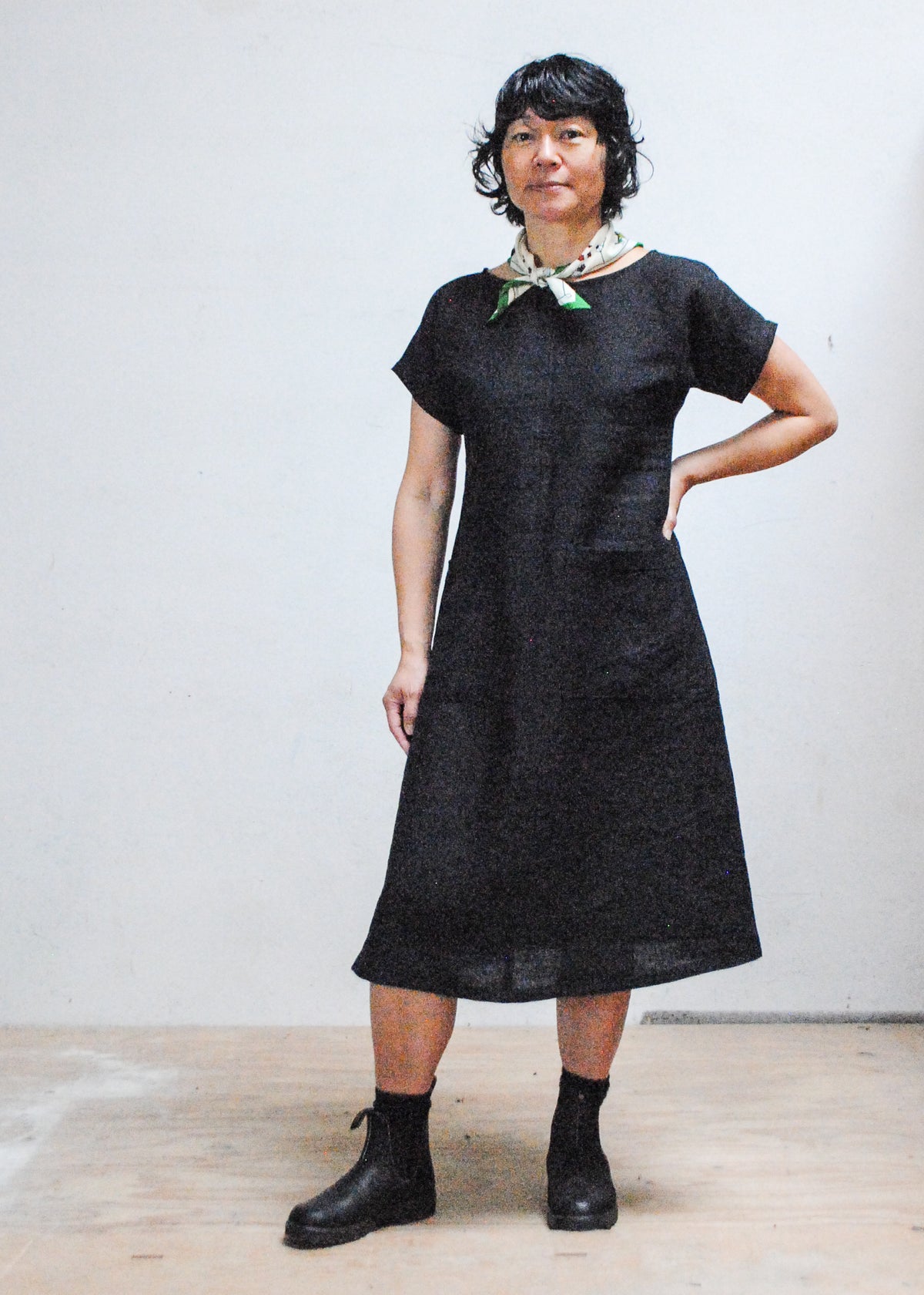Model with hand on hip wearing handmade black linen dress