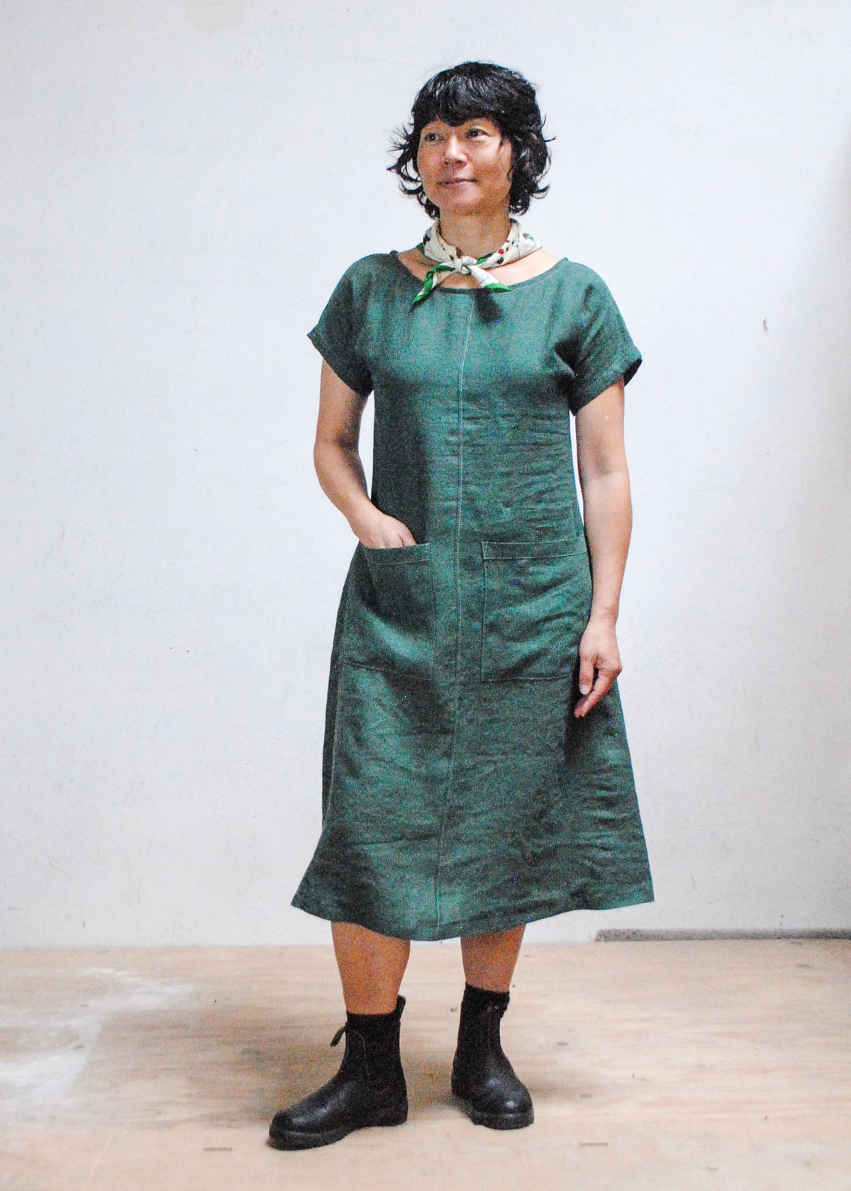Model with hands in pockets wearing Shift + Wheeler Basic Dress in green linen