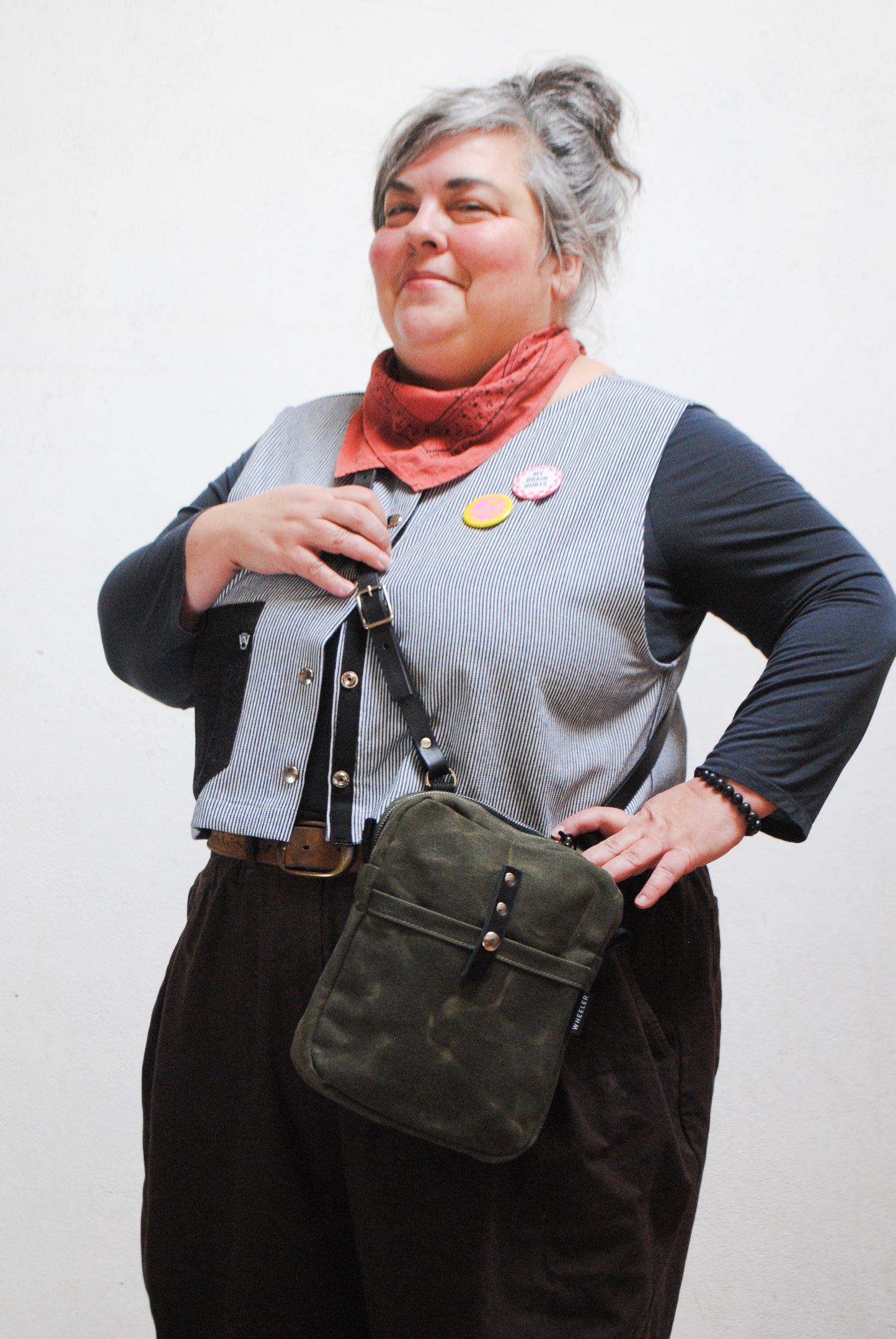 Mini messenger bag worn crossbody, showing strap length and fit