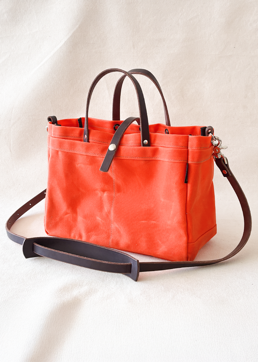 Handmade waxed canvas tool bag in orange with dark brown leather strap