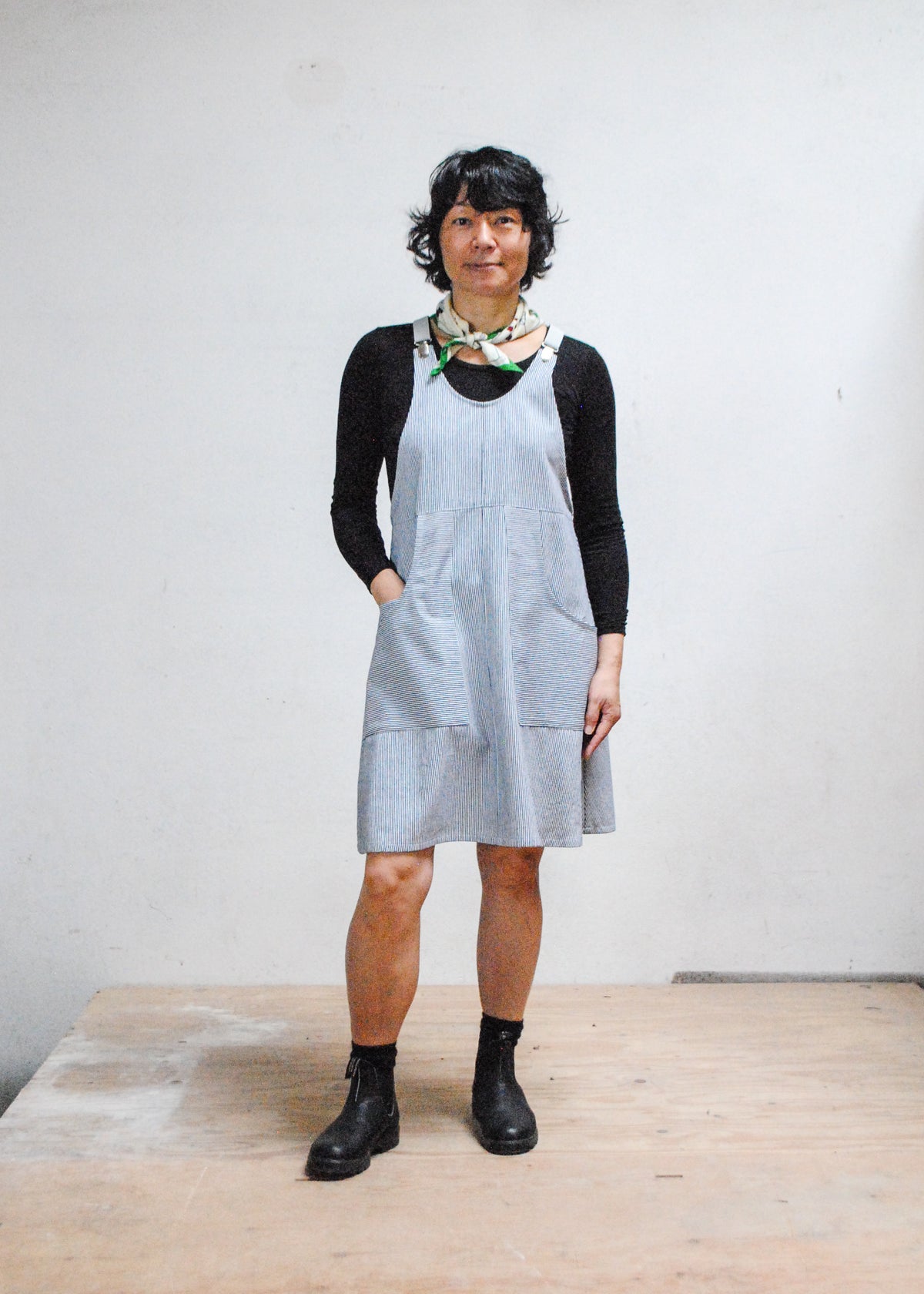 Front view of model wearing railroad stripe suspender dress