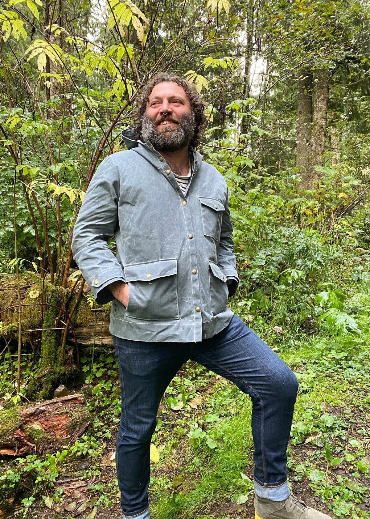 Model wearing Waxed Canvas Raincoat in Slate with hands in pockets of raincoat.