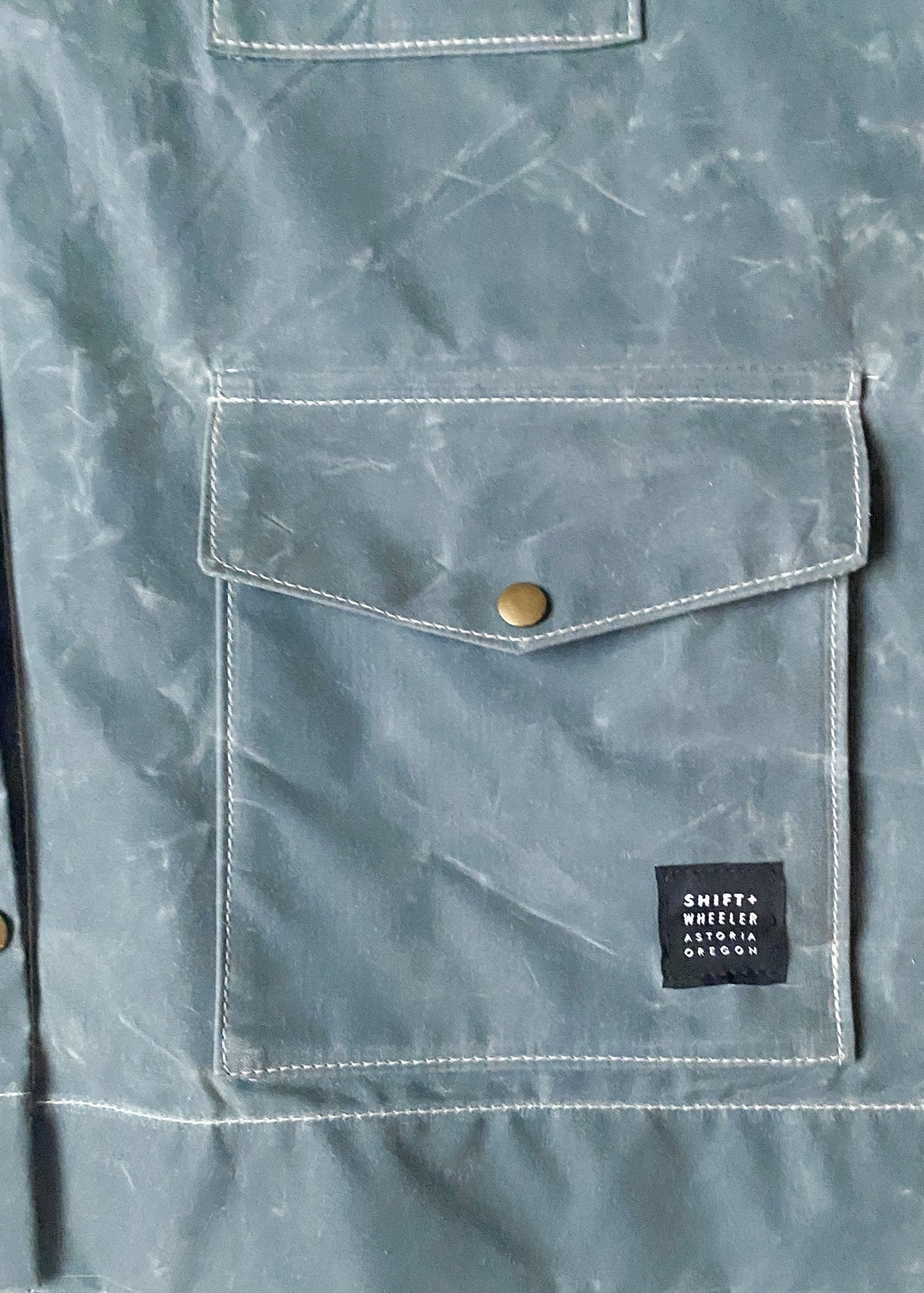 Pocket detail of Waxed Canvas Raincoat in Slate.