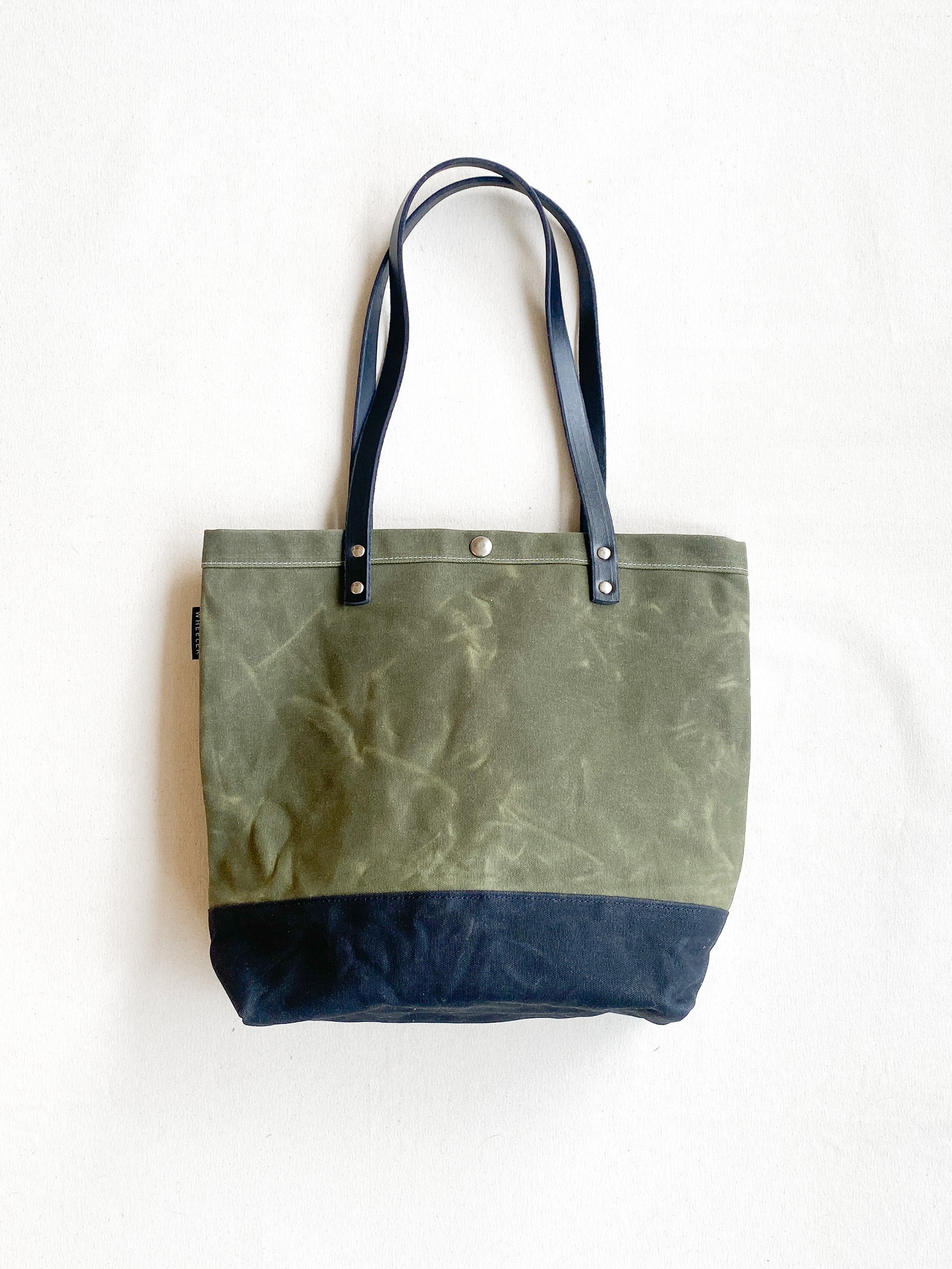 Olive and black tote with leather handles. Waxed Canvas and railroad denim on the inside. 