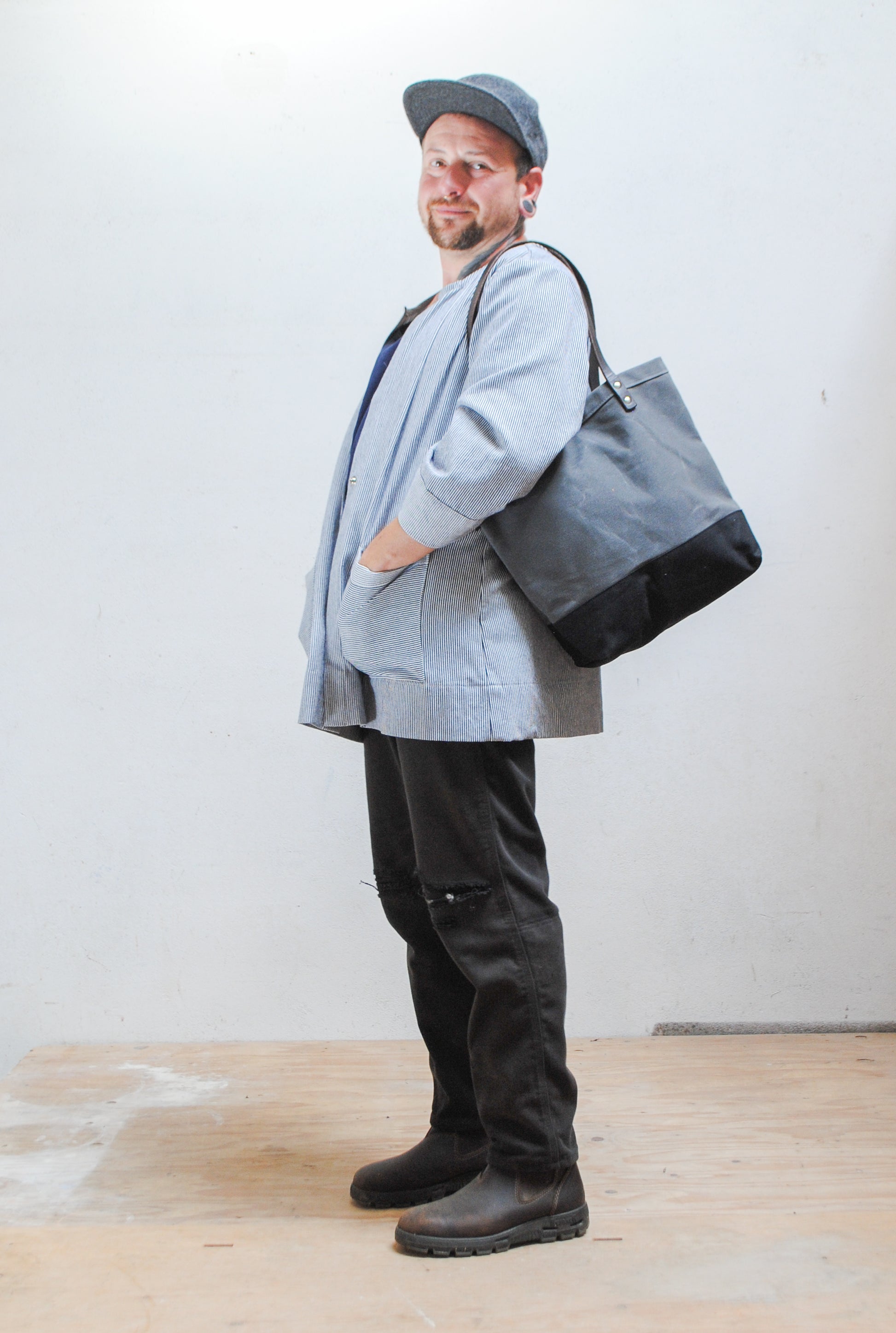 The utility tote has handles long enough so you can sling the bag over your shoulder. 