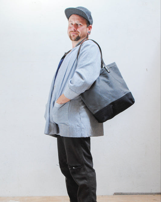 The utility tote has handles long enough so you can sling the bag over your shoulder. 