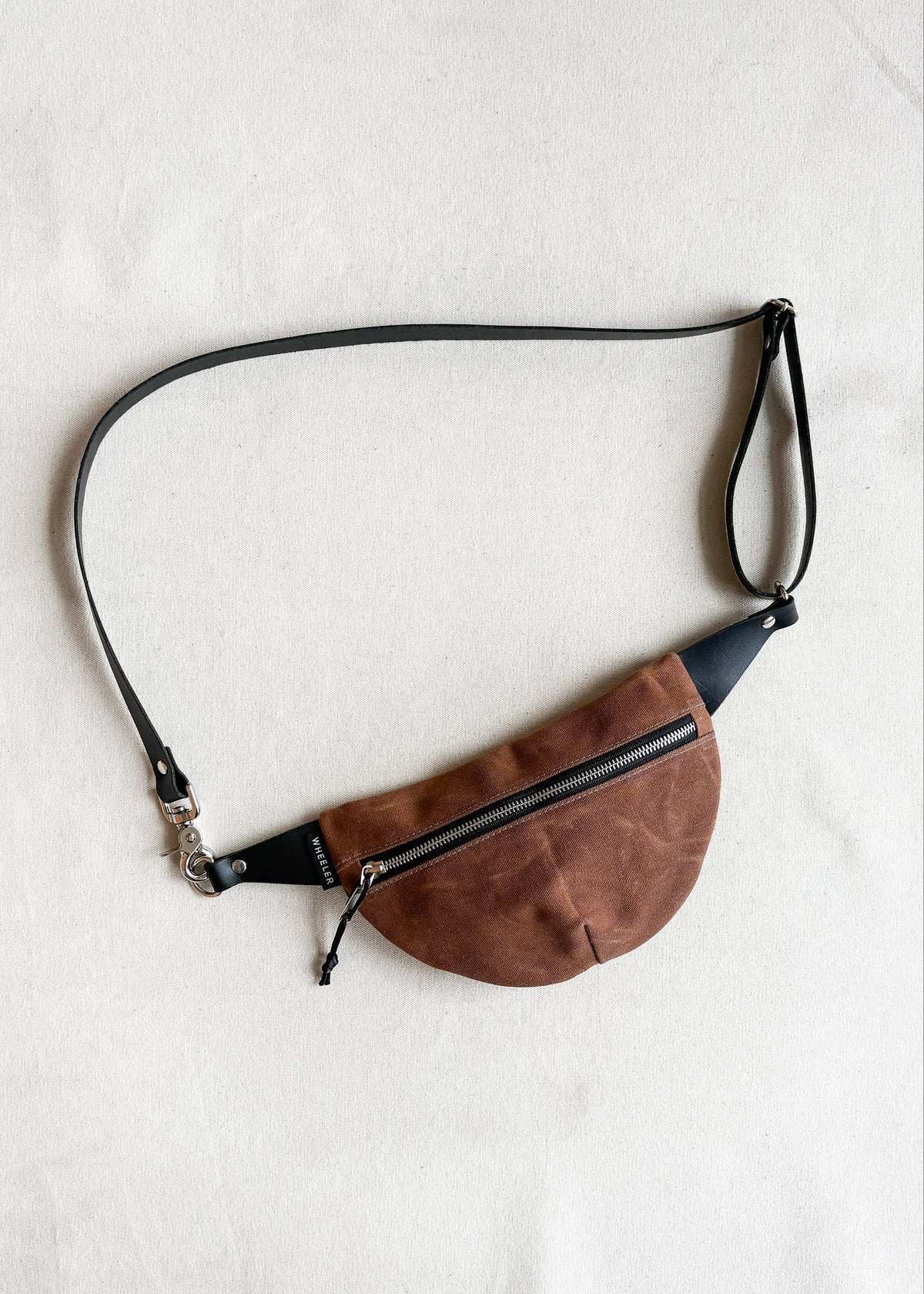 Handmade waxed canvas fanny pack in brown with black leather strap