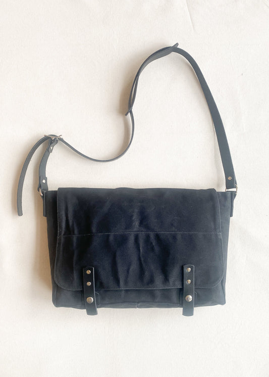 Waxed canvas messenger bag in black with black leather strapping