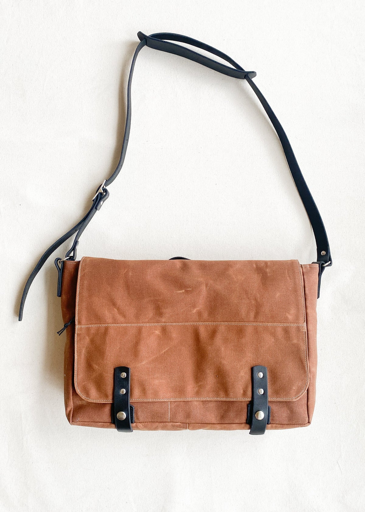 Waxed canvas messenger bag in brown with black leather strapping