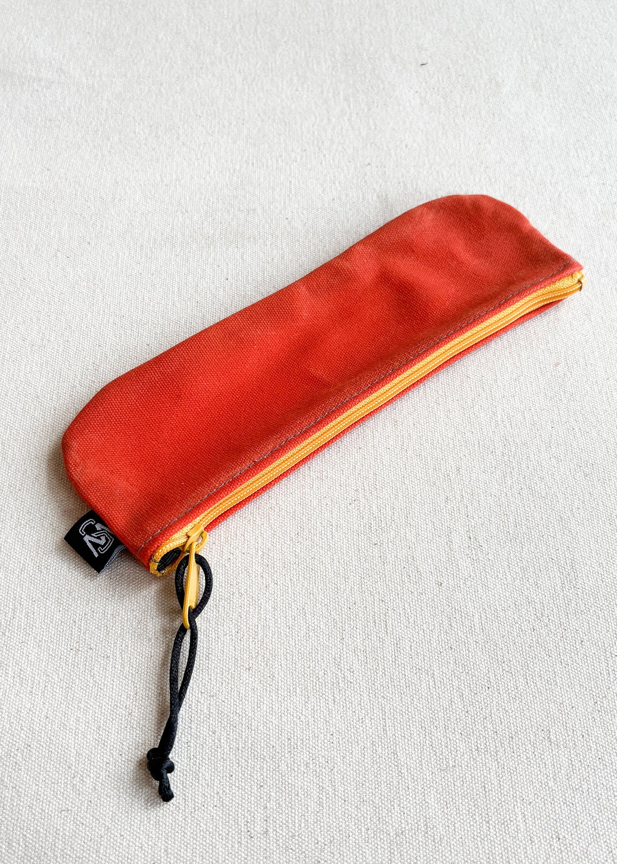 Shift + Wheeler waxed canvas pencil pouch in orange with yellow zipper