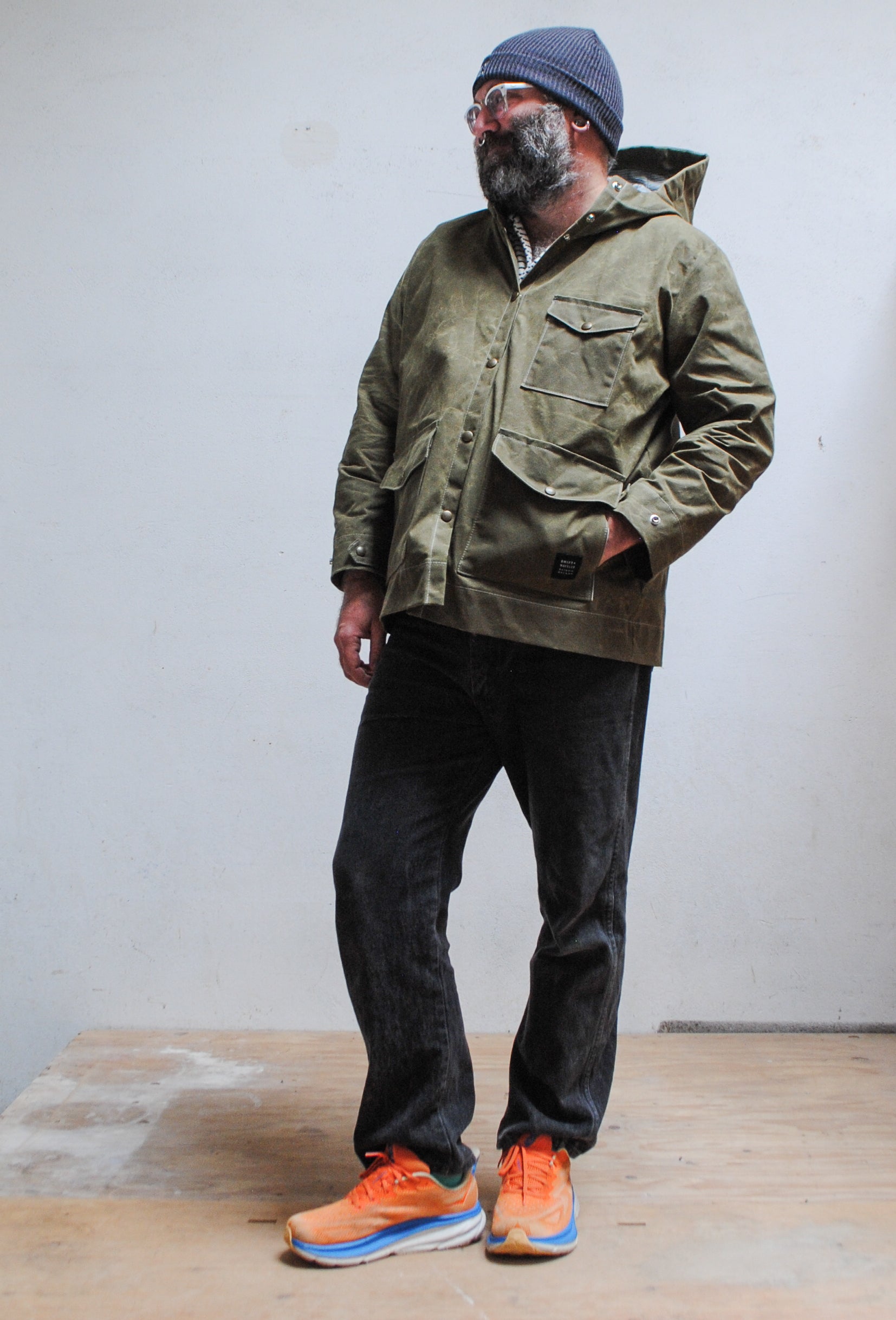 Model wearing olive waxed canvas rain jacket in size L.