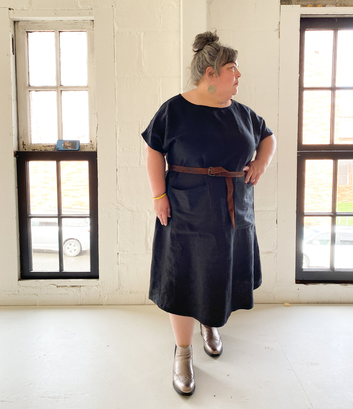 A-line, longer linen dress has two big patch pockets on the front. Styled with a belt and statement shoes. 