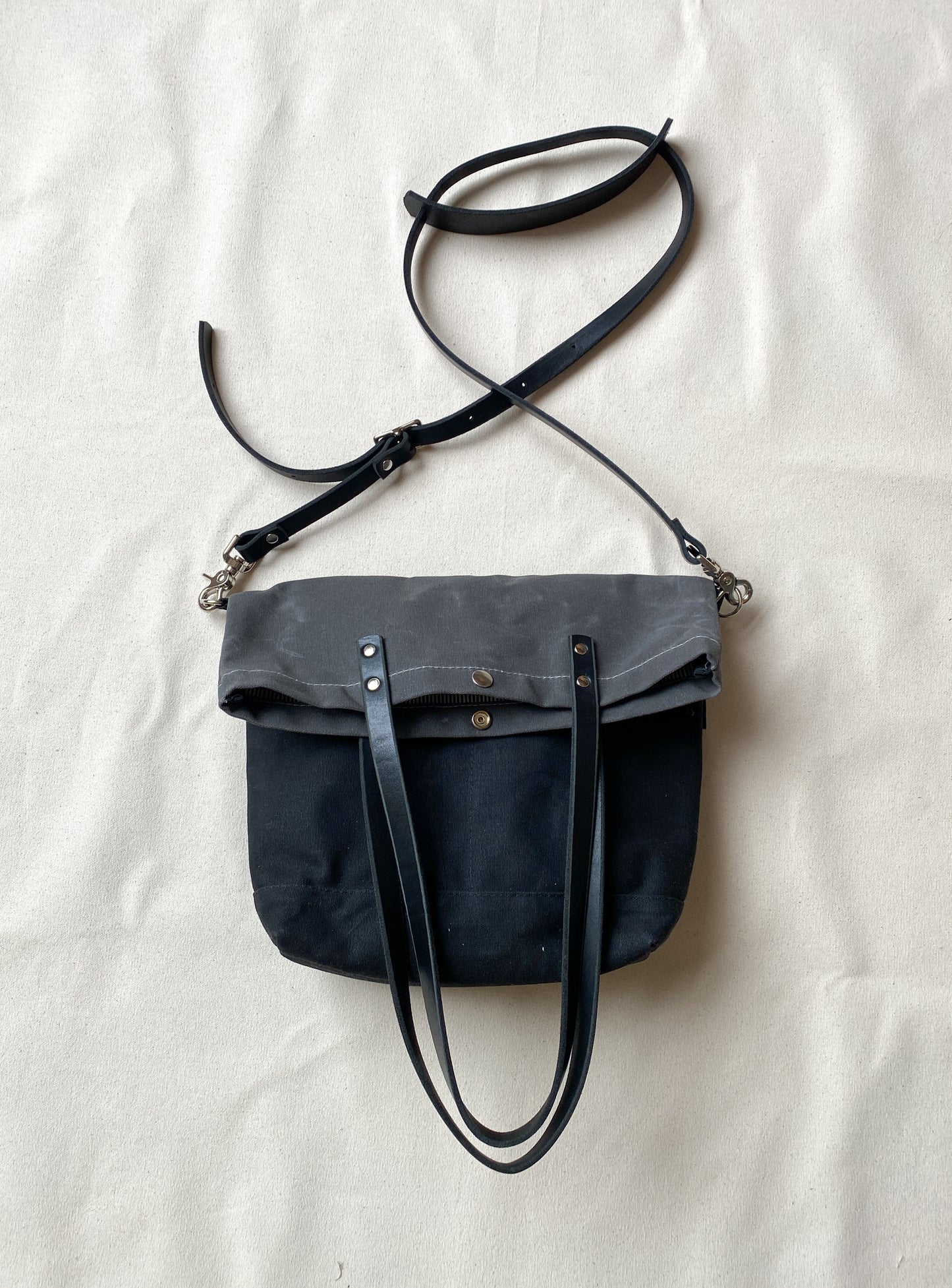Convertible tote in slate and charcoal folded. 