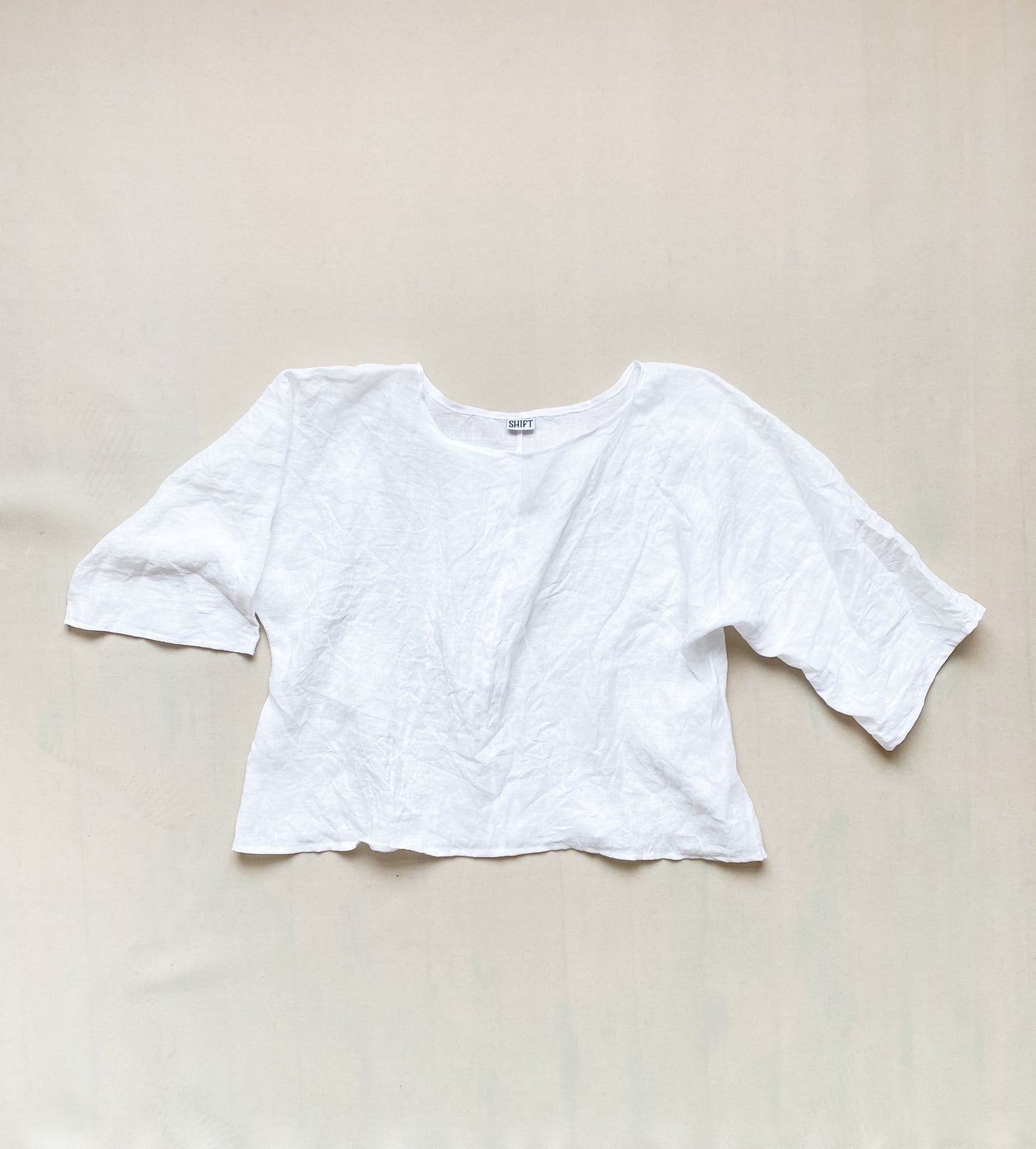 Flat lay of white linen ghost shirt with wrinkles