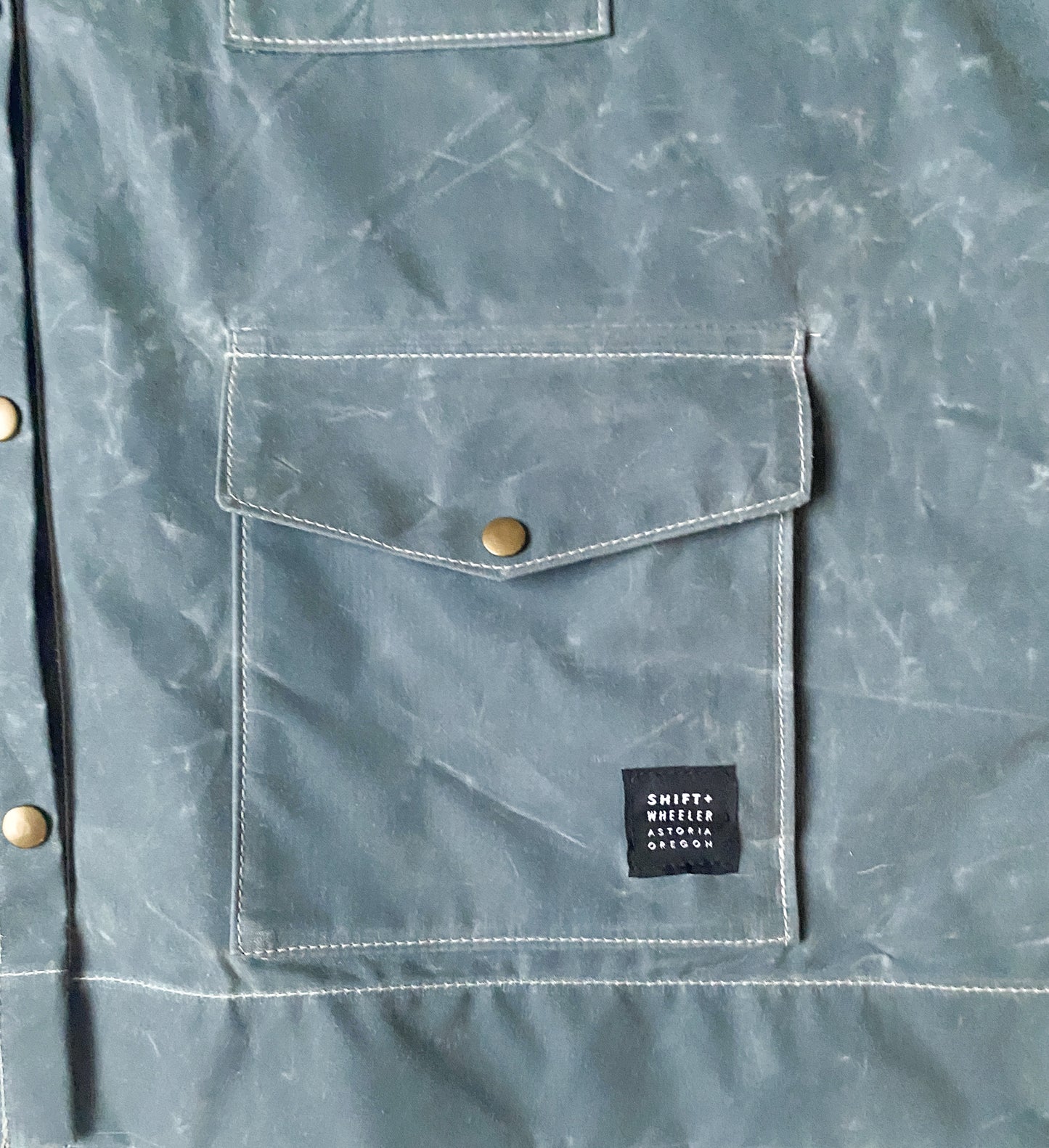 Pocket detail of Waxed Canvas Raincoat in Slate. 