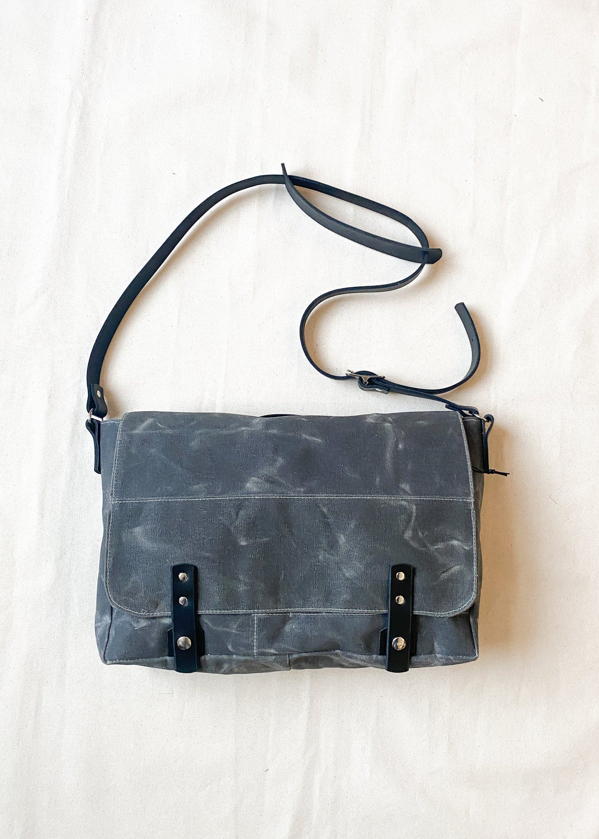 Charcoal waxed canvas messenger bag with black leather straps