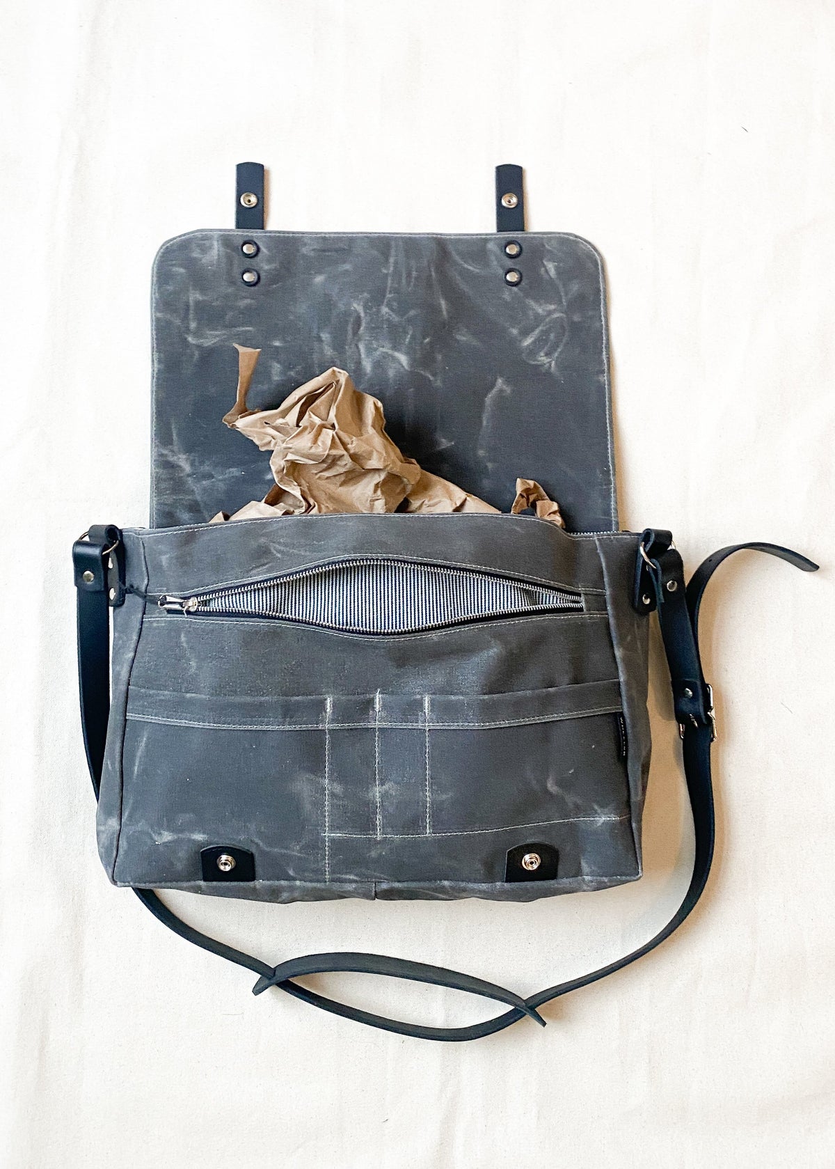 Charcoal waxed canvas messenger bag with black leather straps, open front view