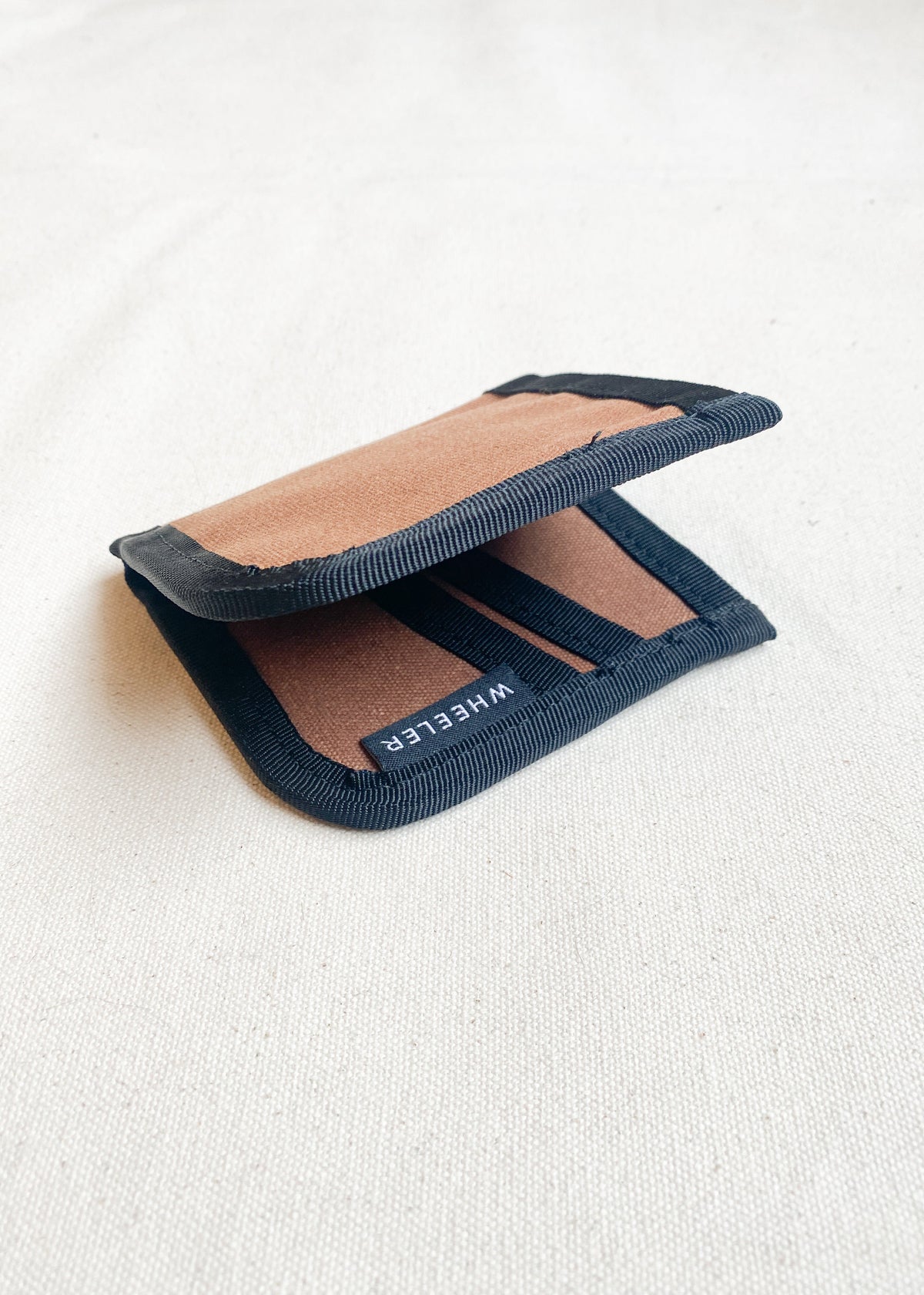 Side view of waxed canvas wallet in brown